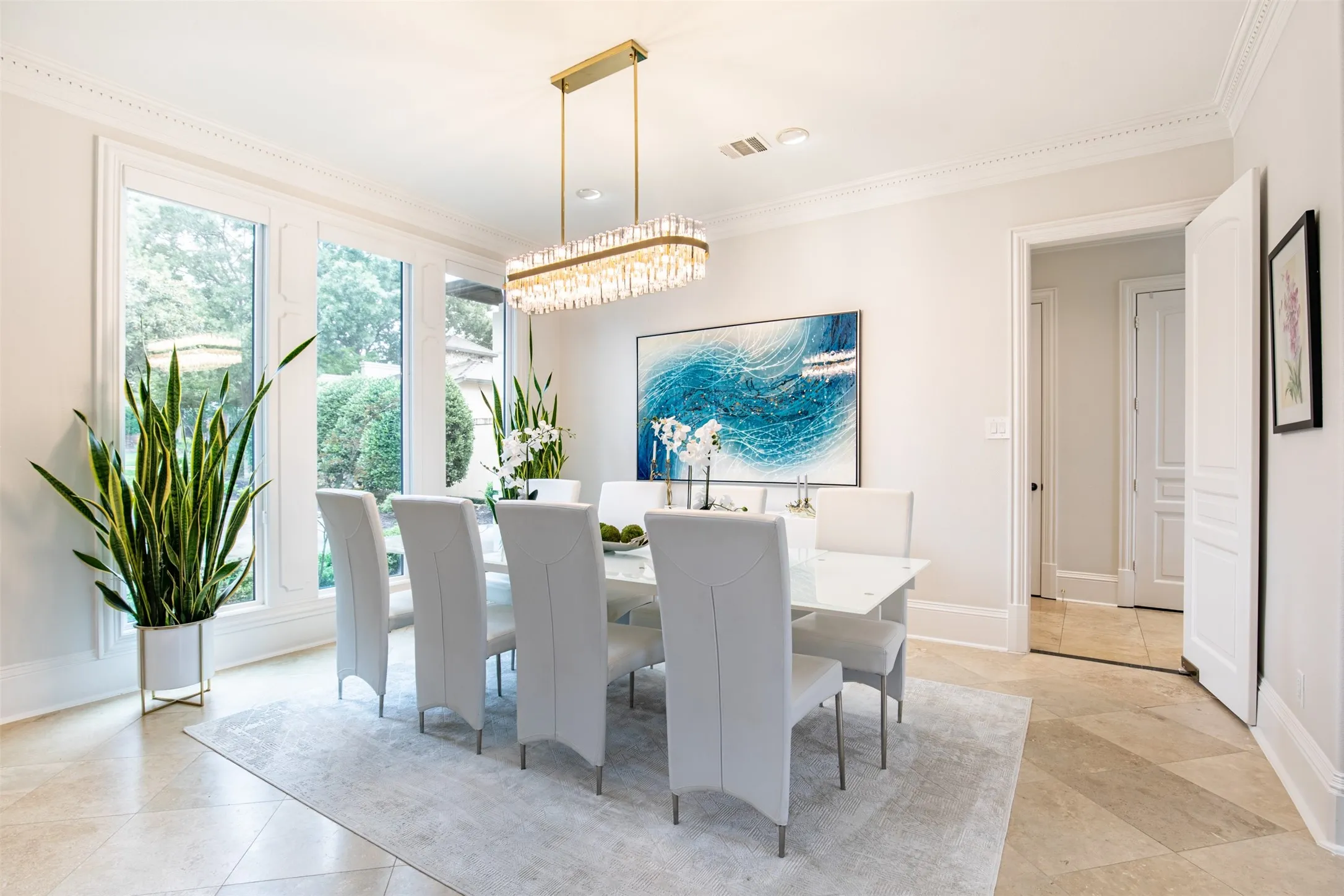 Dining area with expansive windows, decorative crown molding, and neutral wall tones