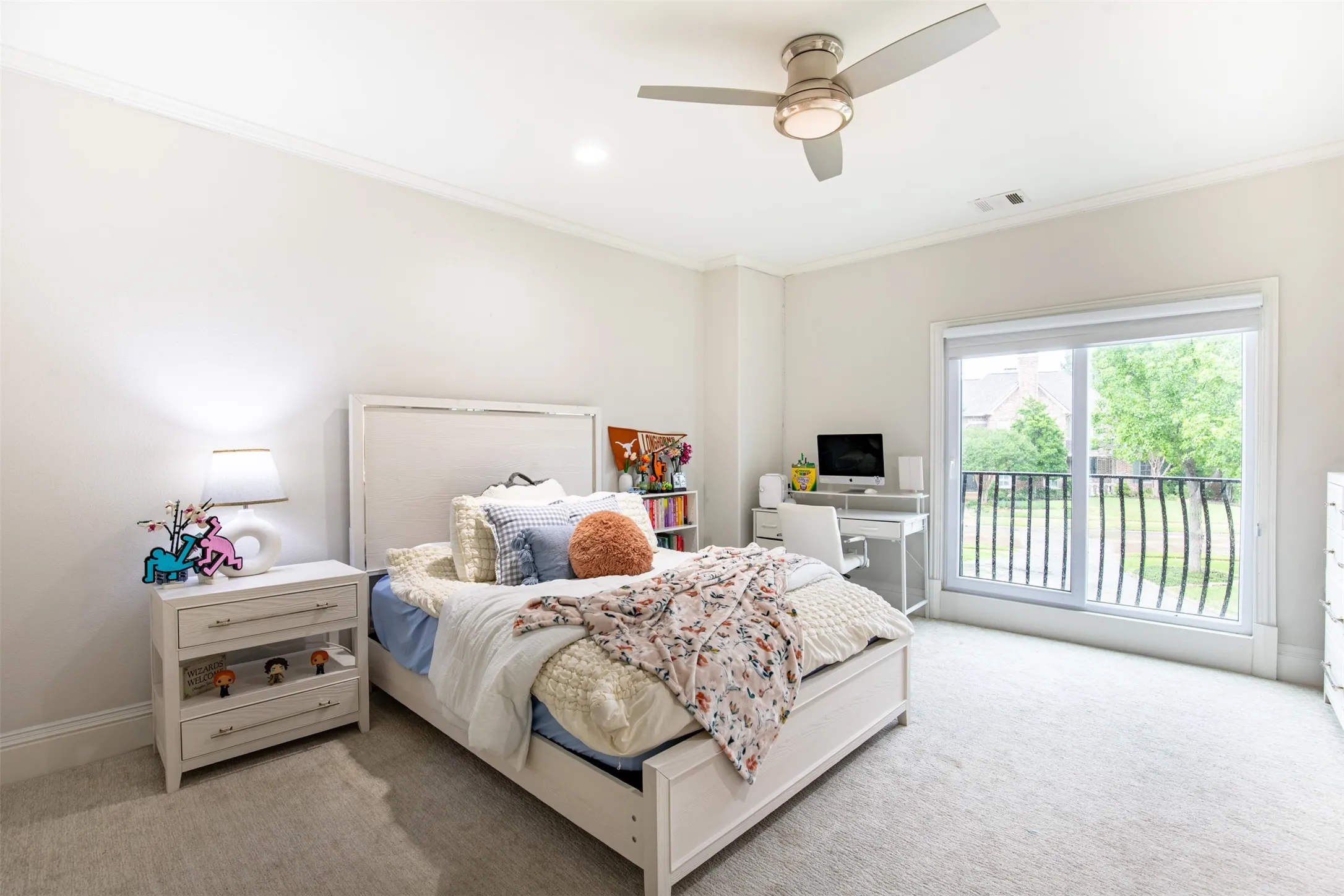 Bright room featuring a ceiling fan with integrated lighting, crown molding, and light-colored carpet