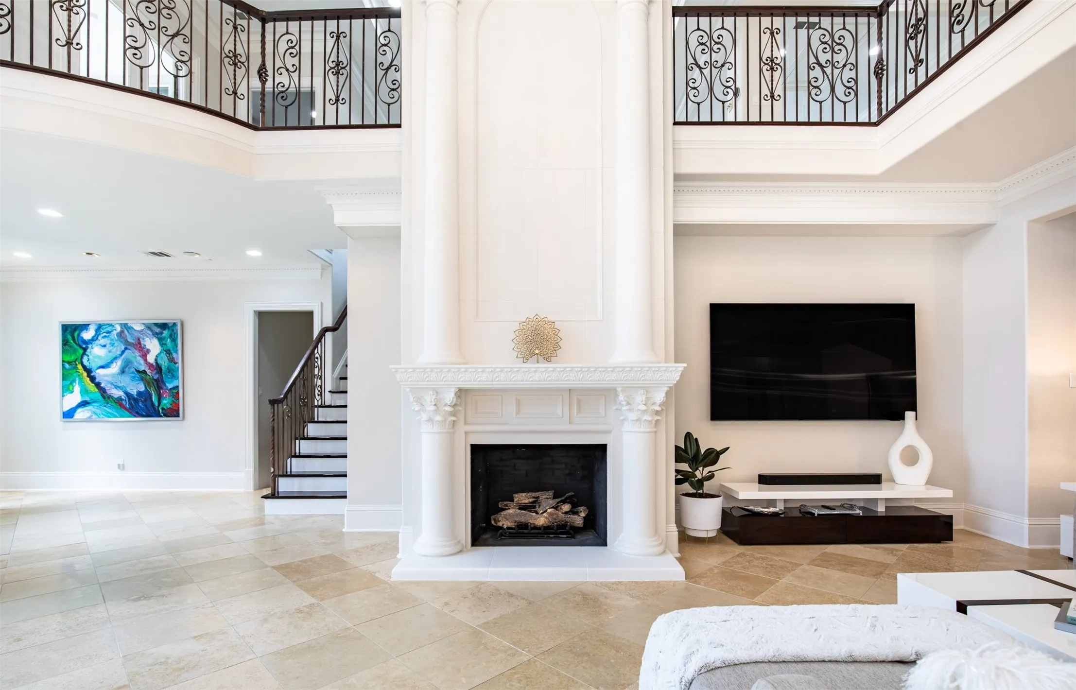 Two-story interior with a prominent fireplace featuring decorative corbels and a mantel