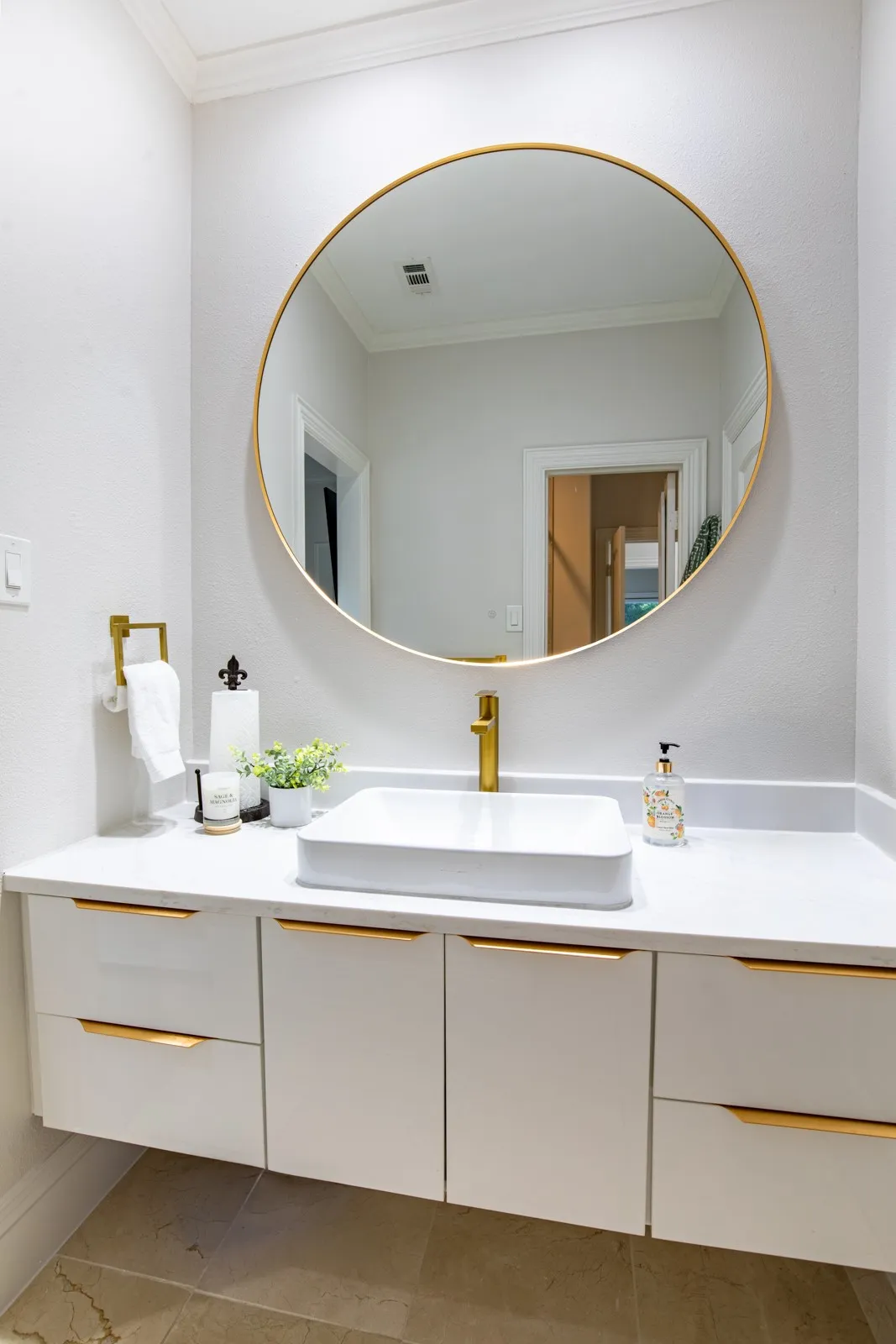 Modern floating vanity with a rectangular vessel sink, gold-finish faucet, and coordinating hardware