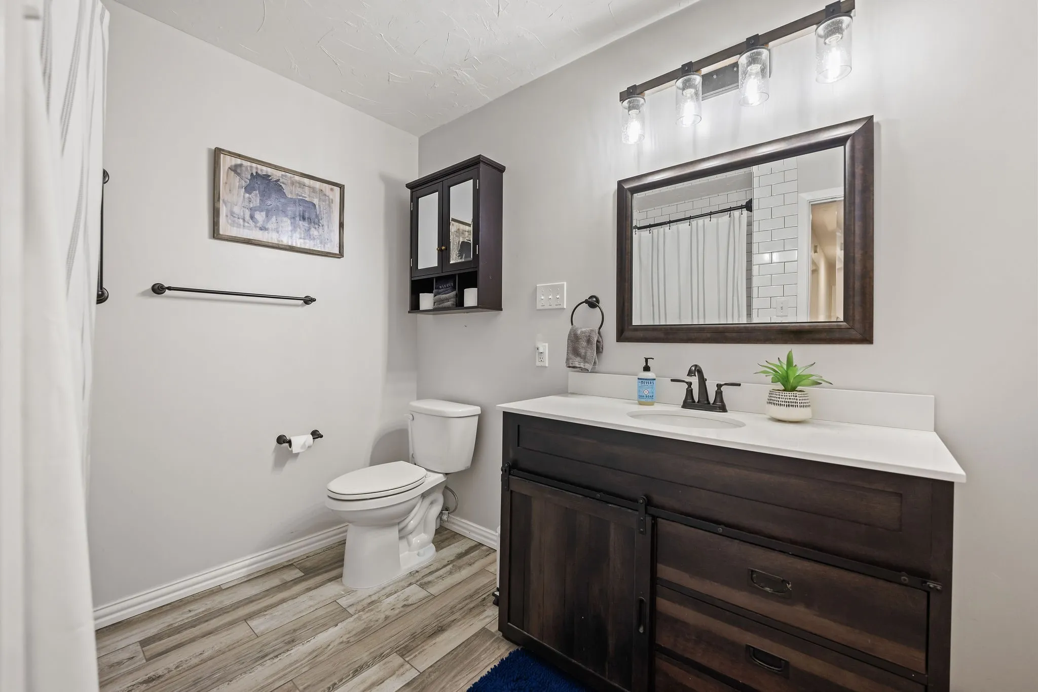 Bathroom featuring a dark wood-finish vanity with a white countertop and rectangular undermount sink
