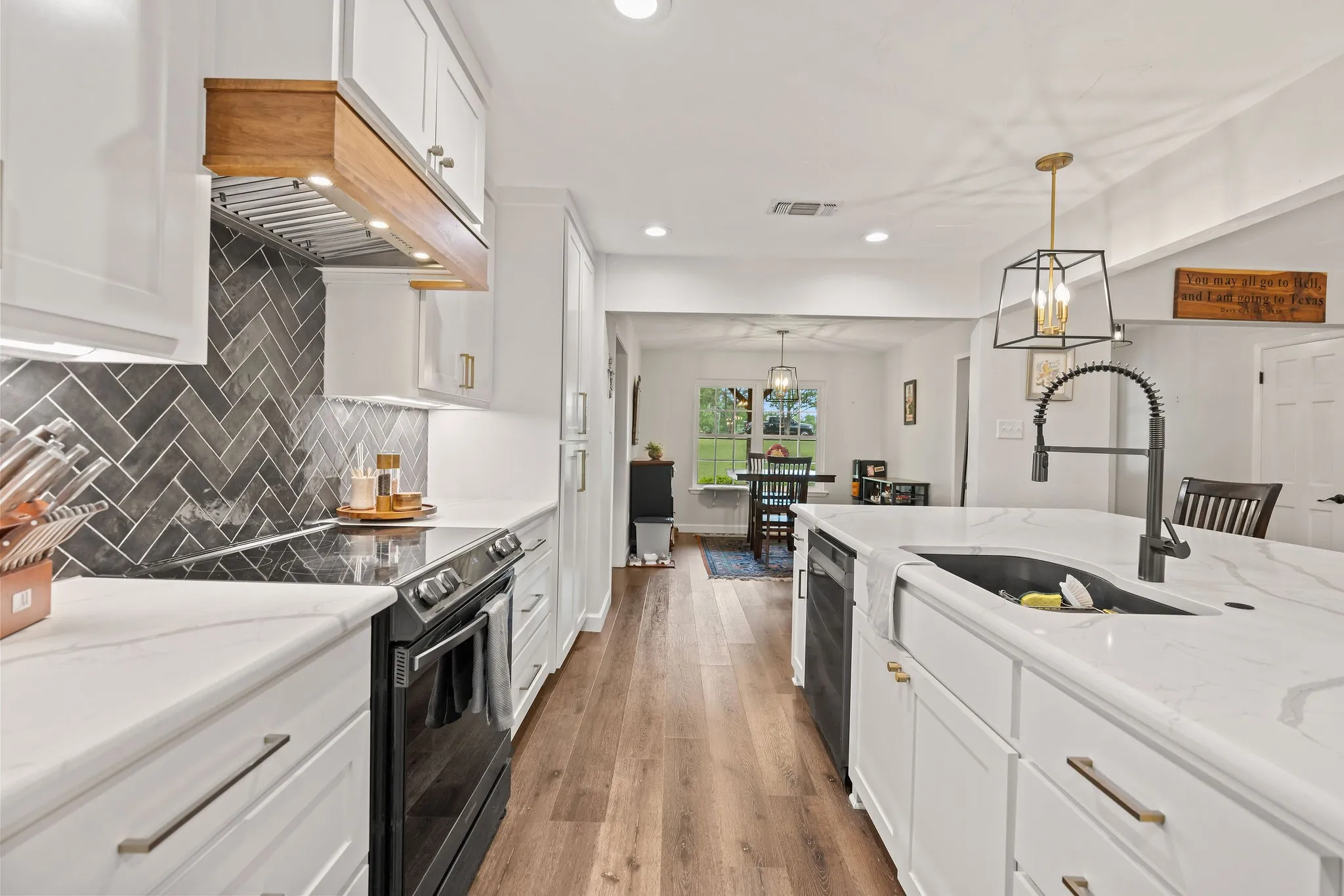 Modern kitchen featuring white shaker cabinetry and a large center island with a farmhouse sink