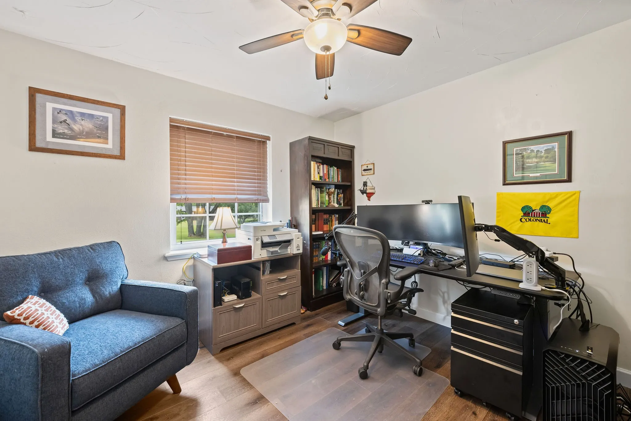 Versatile room with wood-finish flooring and a ceiling fan with integrated lighting