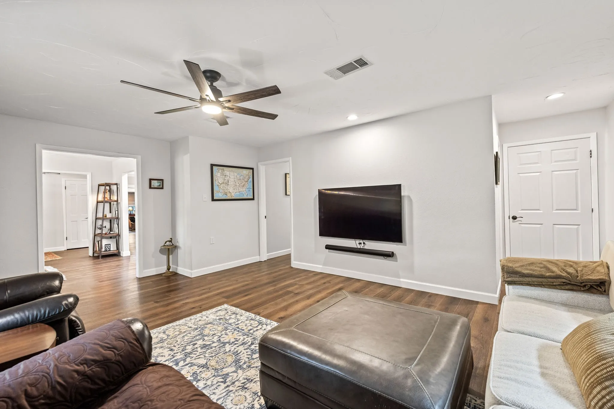 Spacious room featuring wood-finish flooring, recessed lighting, and a ceiling fan