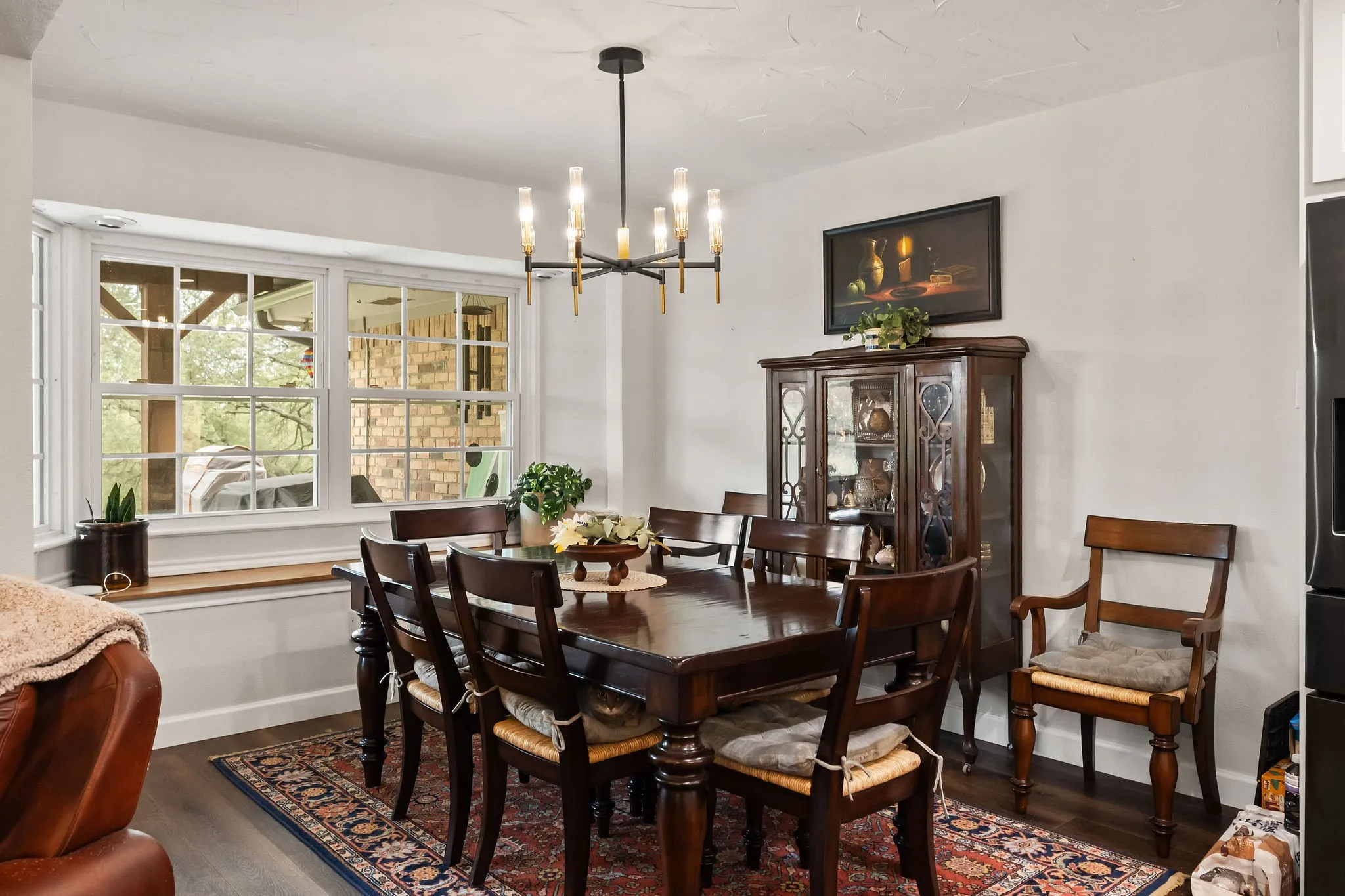 Dining area featuring wood-finish flooring and a contemporary chandelier