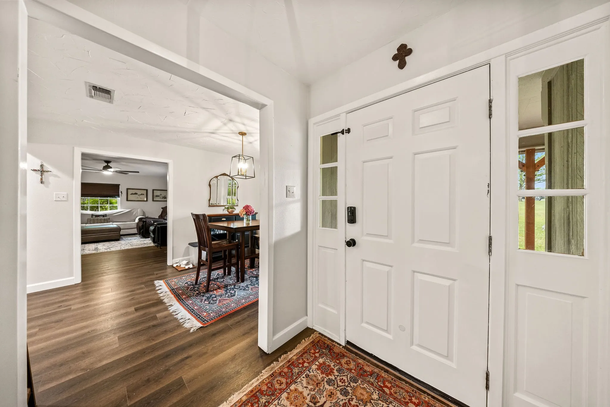 Entryway featuring a paneled front door with sidelights, wood-finish flooring, and bright white walls