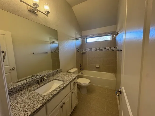 Bathroom featuring a vanity with a granite countertop, undermount sink, and chrome fixtures