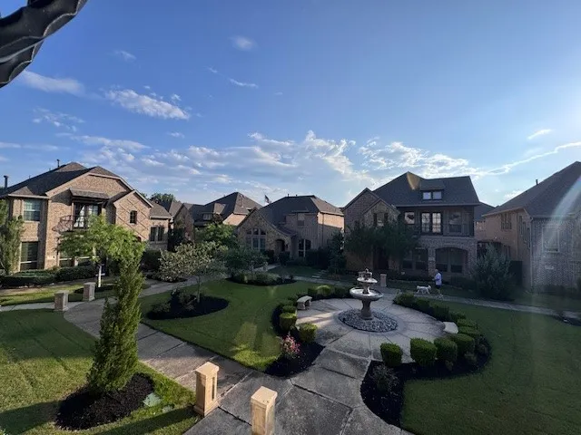 Central courtyard featuring a tiered fountain, manicured lawns, and mature landscaping