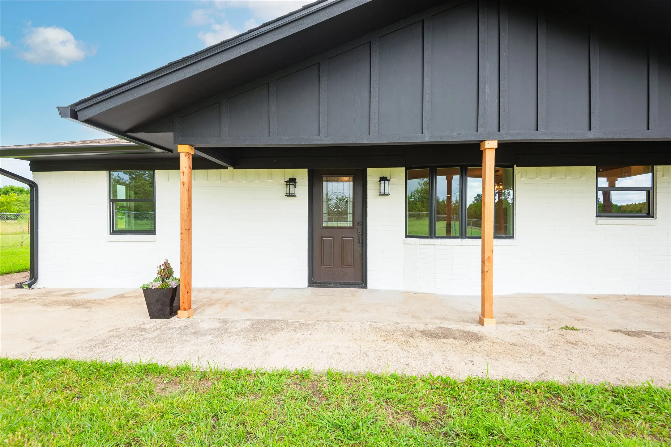 Contemporary exterior featuring white brick siding and dark trim