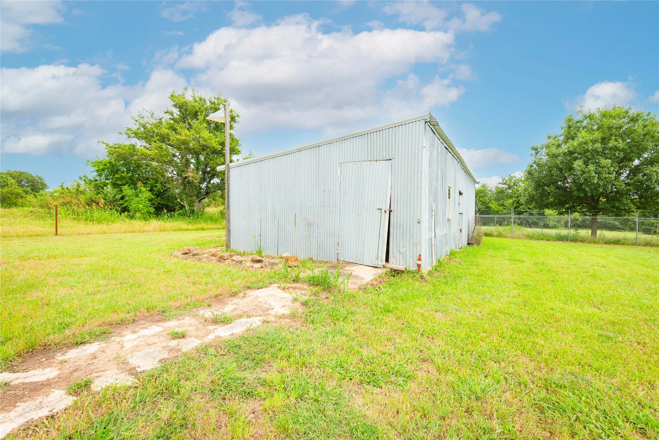 Metal-sided utility building with a single entry door and multiple side openings