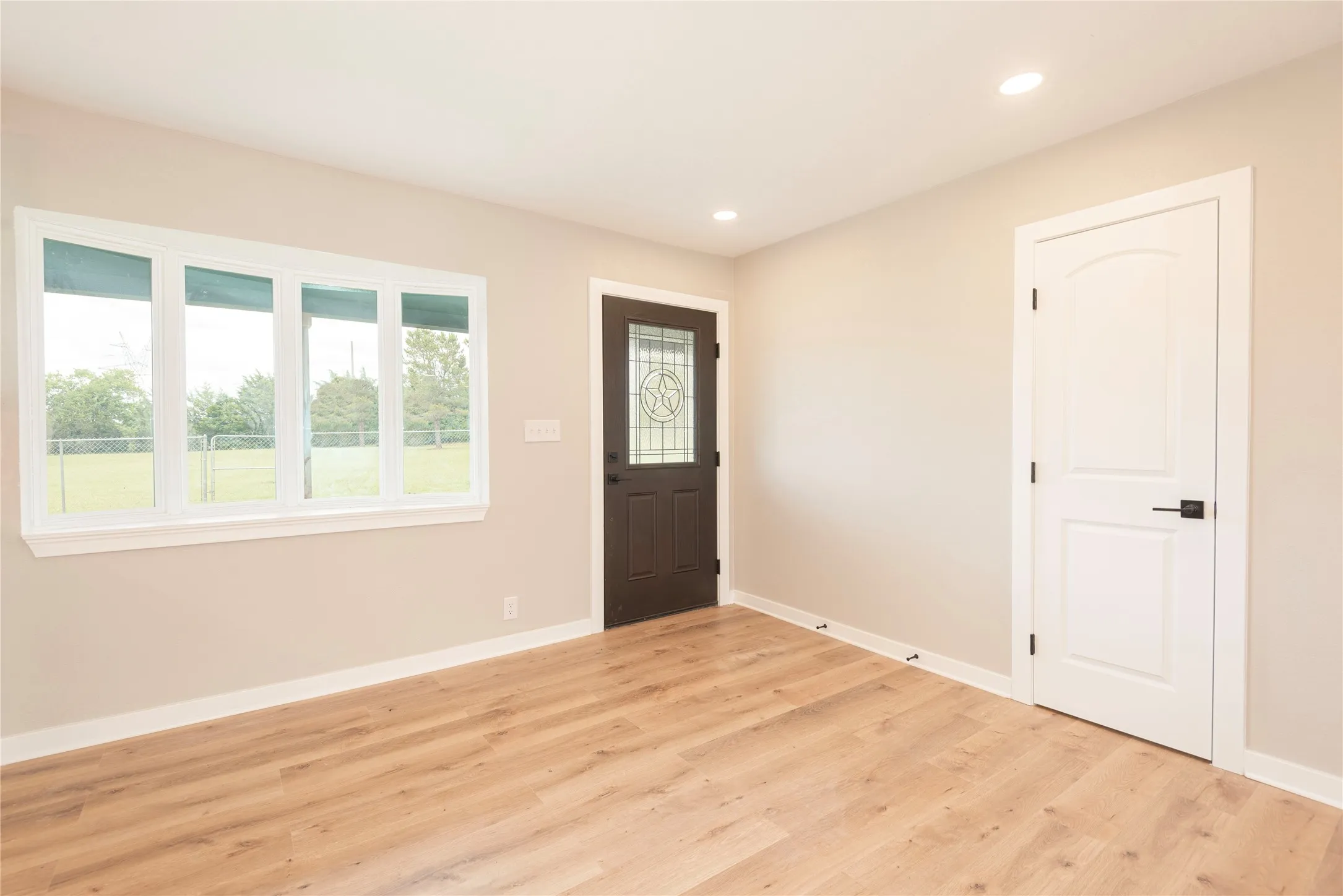 Bright interior space featuring light wood-finish flooring, recessed lighting, and a neutral wall palette