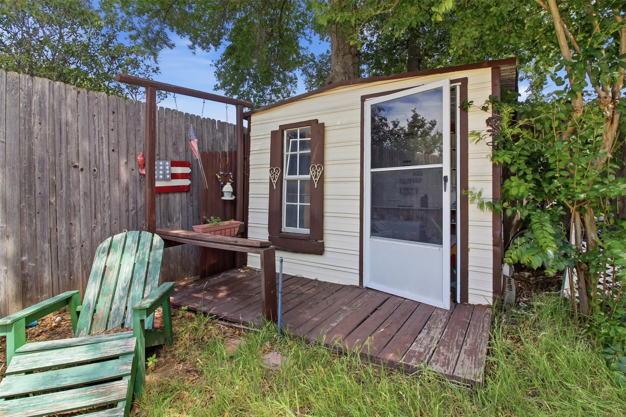 Outdoor storage shed featuring horizontal siding and a full-light storm door