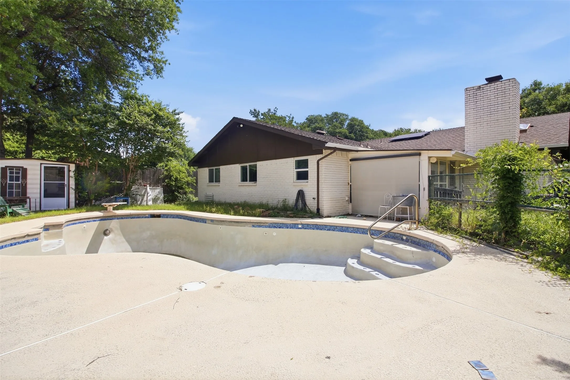 In-ground swimming pool with integrated steps and a concrete surround