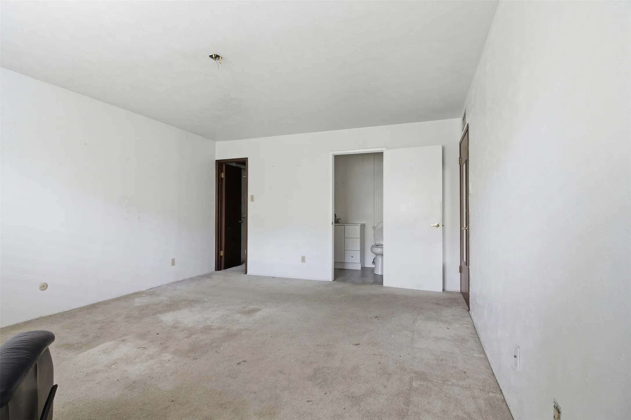 Spacious room featuring neutral carpeting and white walls