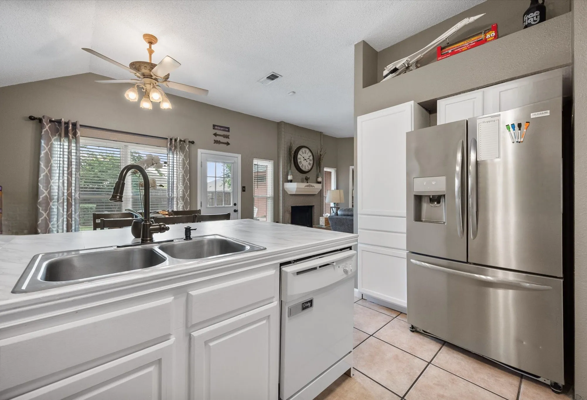 Kitchen island featuring a double basin sink, gooseneck faucet, and integrated dishwasher