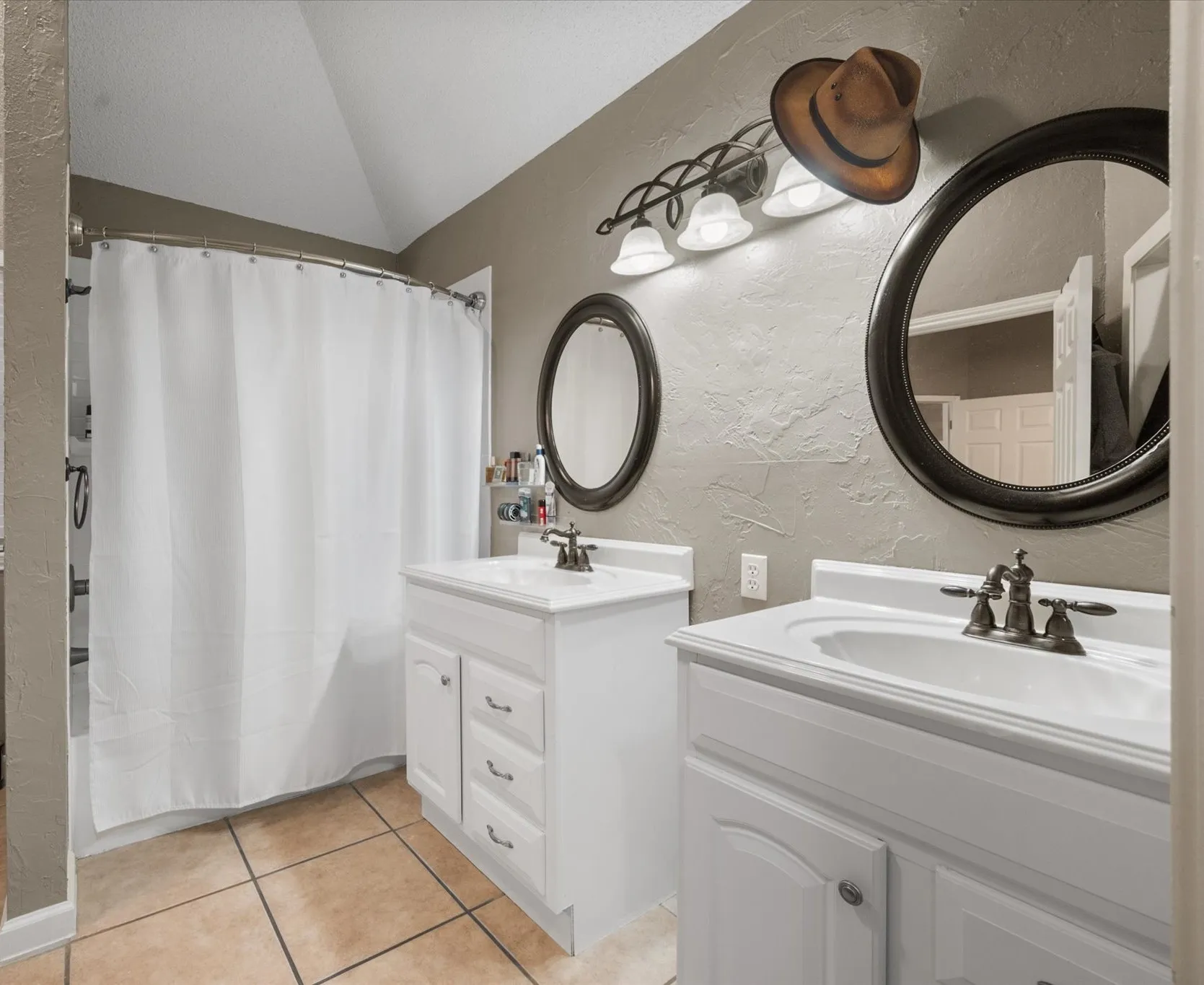 Dual vanity sinks with white cabinetry and integrated countertops