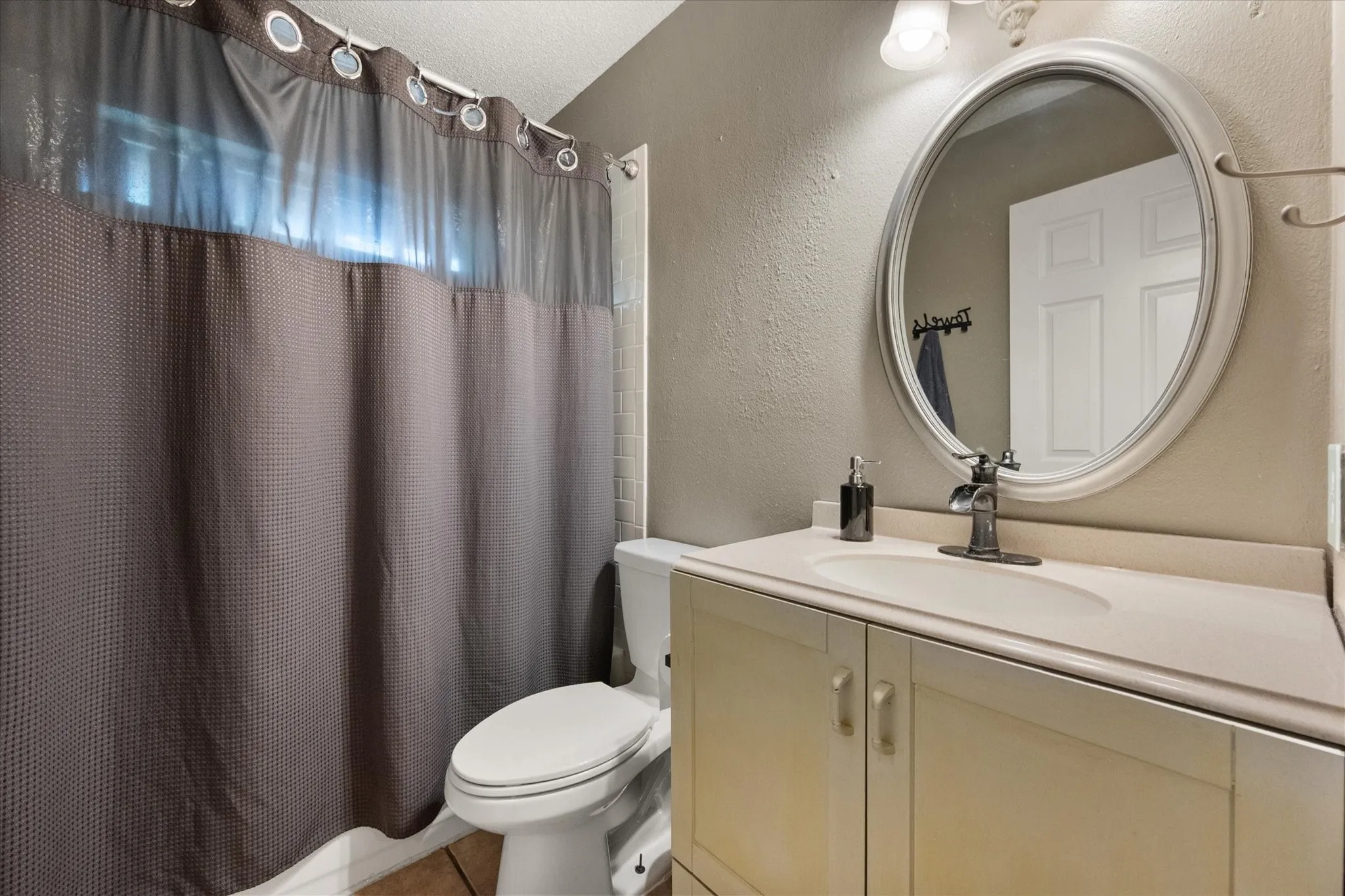 Bathroom vanity featuring a built-in sink and a wall-mounted oval mirror