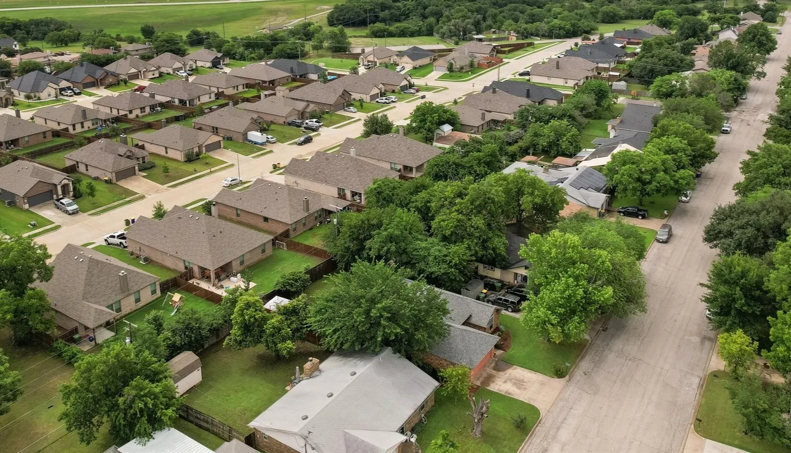 Residential neighborhood featuring single-story homes with shingled roofs and fenced backyards