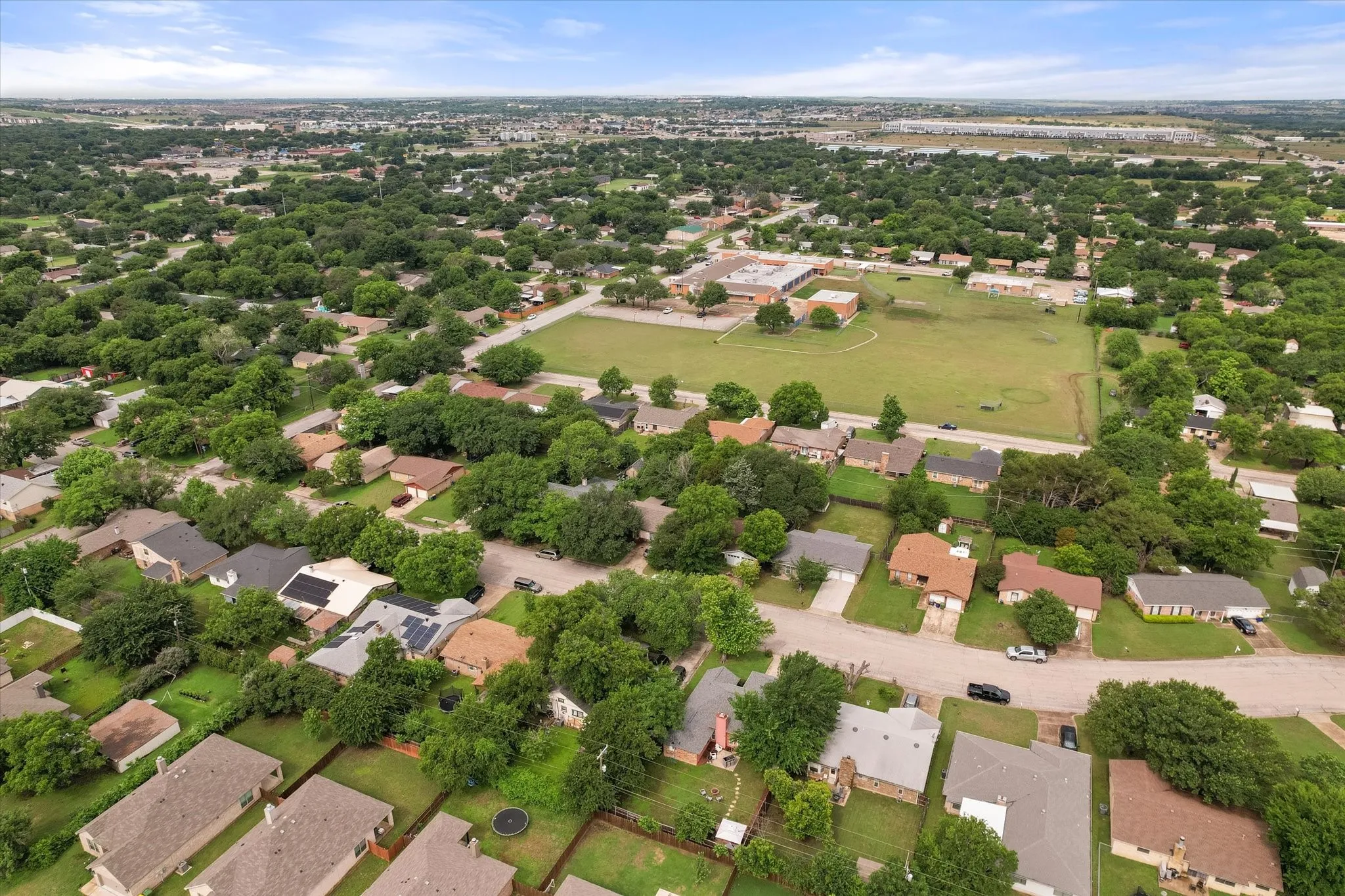 Aerial perspective showcasing a residential neighborhood with numerous mature trees