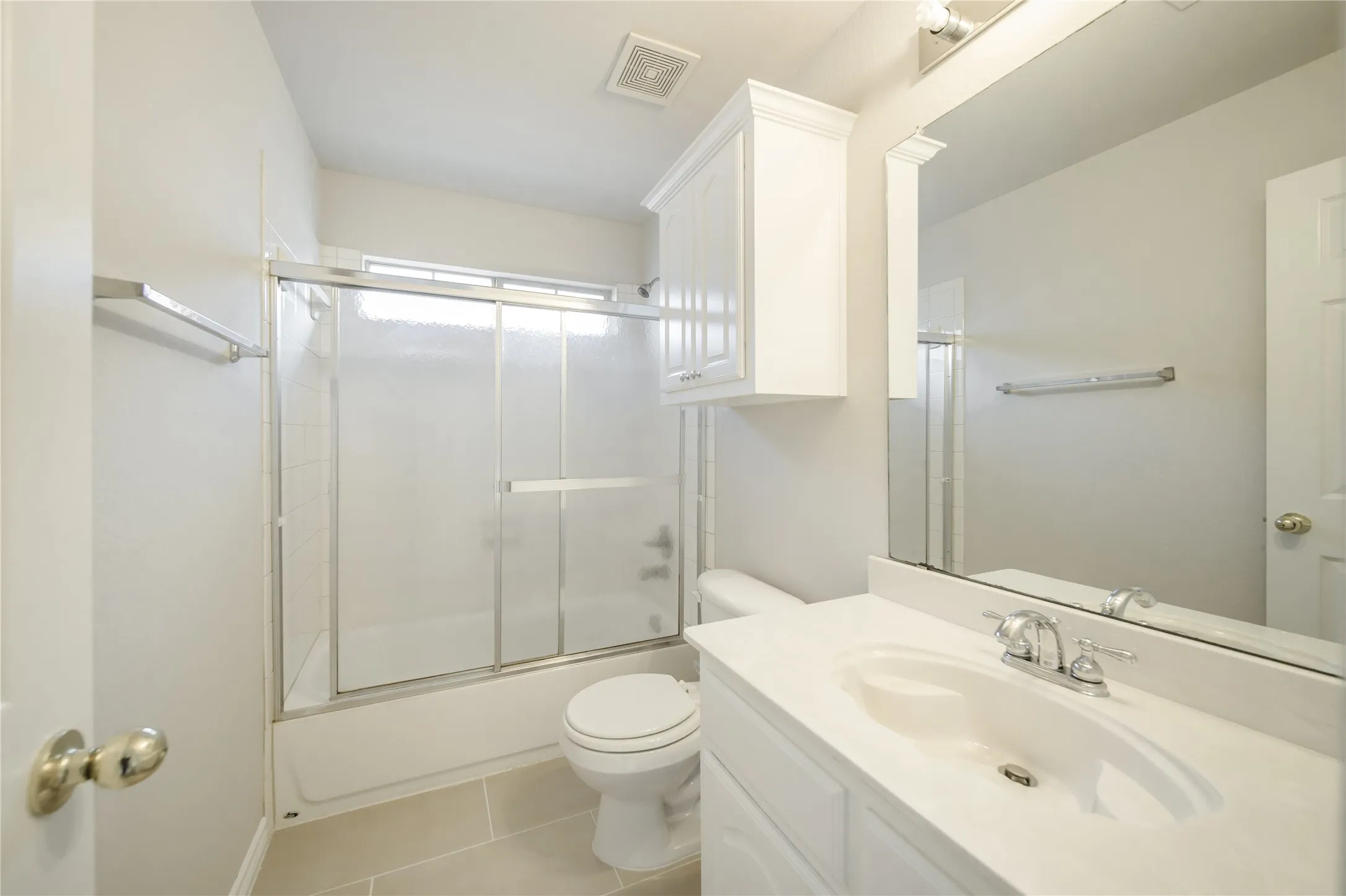 Bathroom featuring a white vanity with an integrated sink, polished chrome faucet, and a large wall-mounted mirror