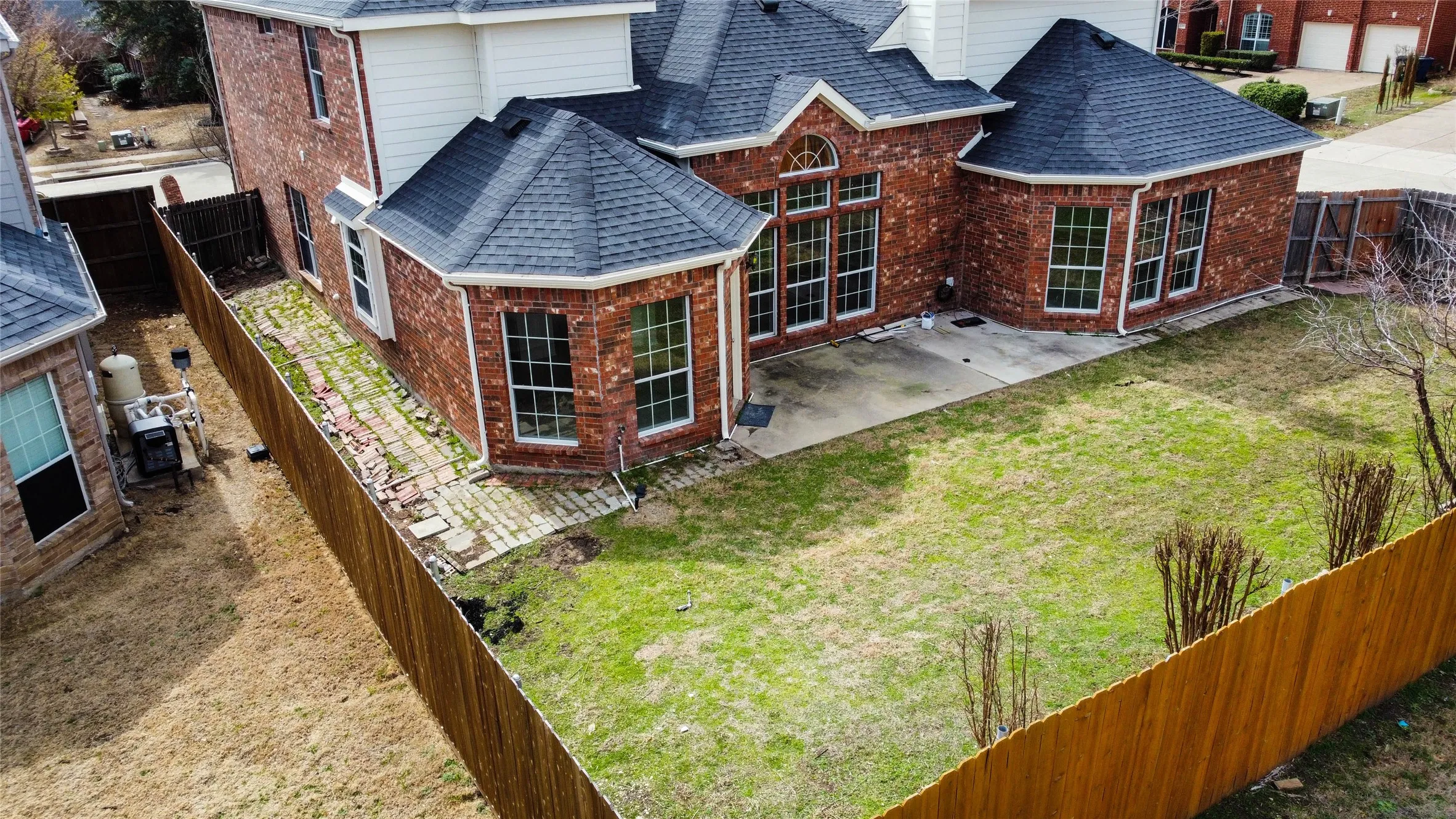 Brick exterior with white trim and a dark shingle roof