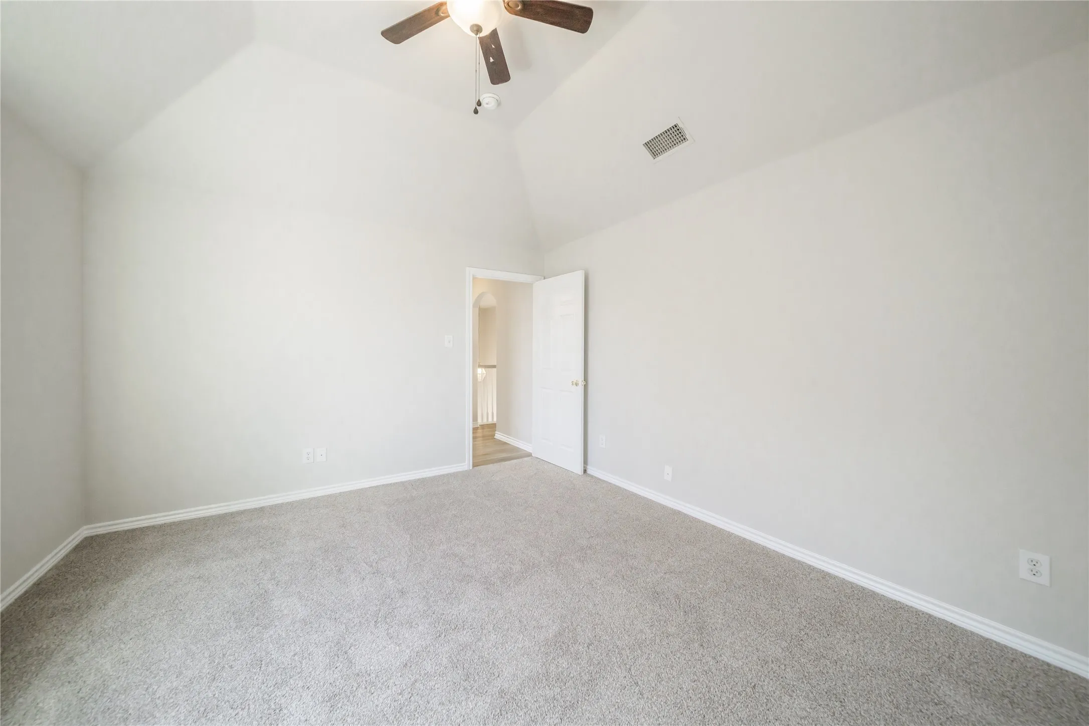 Room with vaulted ceiling, neutral gray carpet, and white baseboards