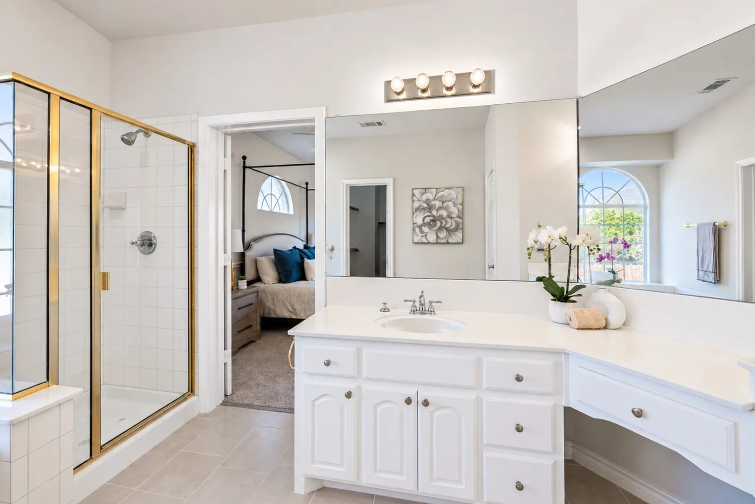 White vanity with integrated sink, extensive countertop space, and dedicated seated vanity area