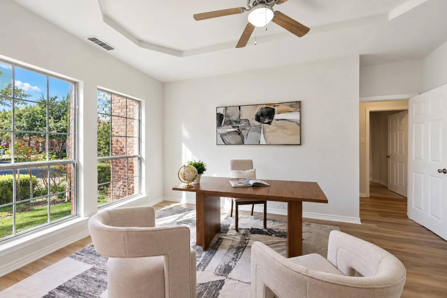 Tray ceiling with a ceiling fan, wood-finish flooring, and white interior doors