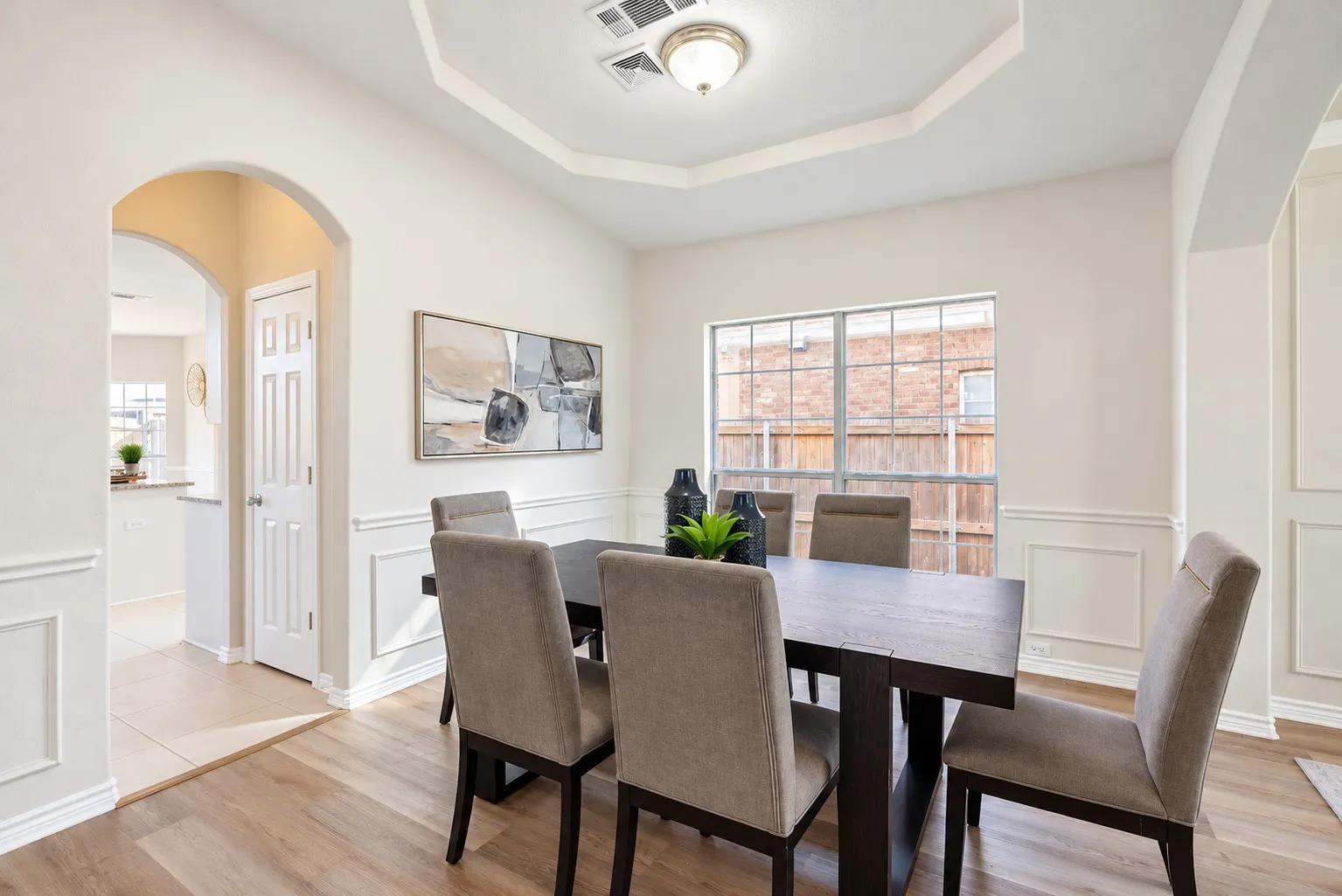 Wood-finish flooring with wainscoting details and arched entryways