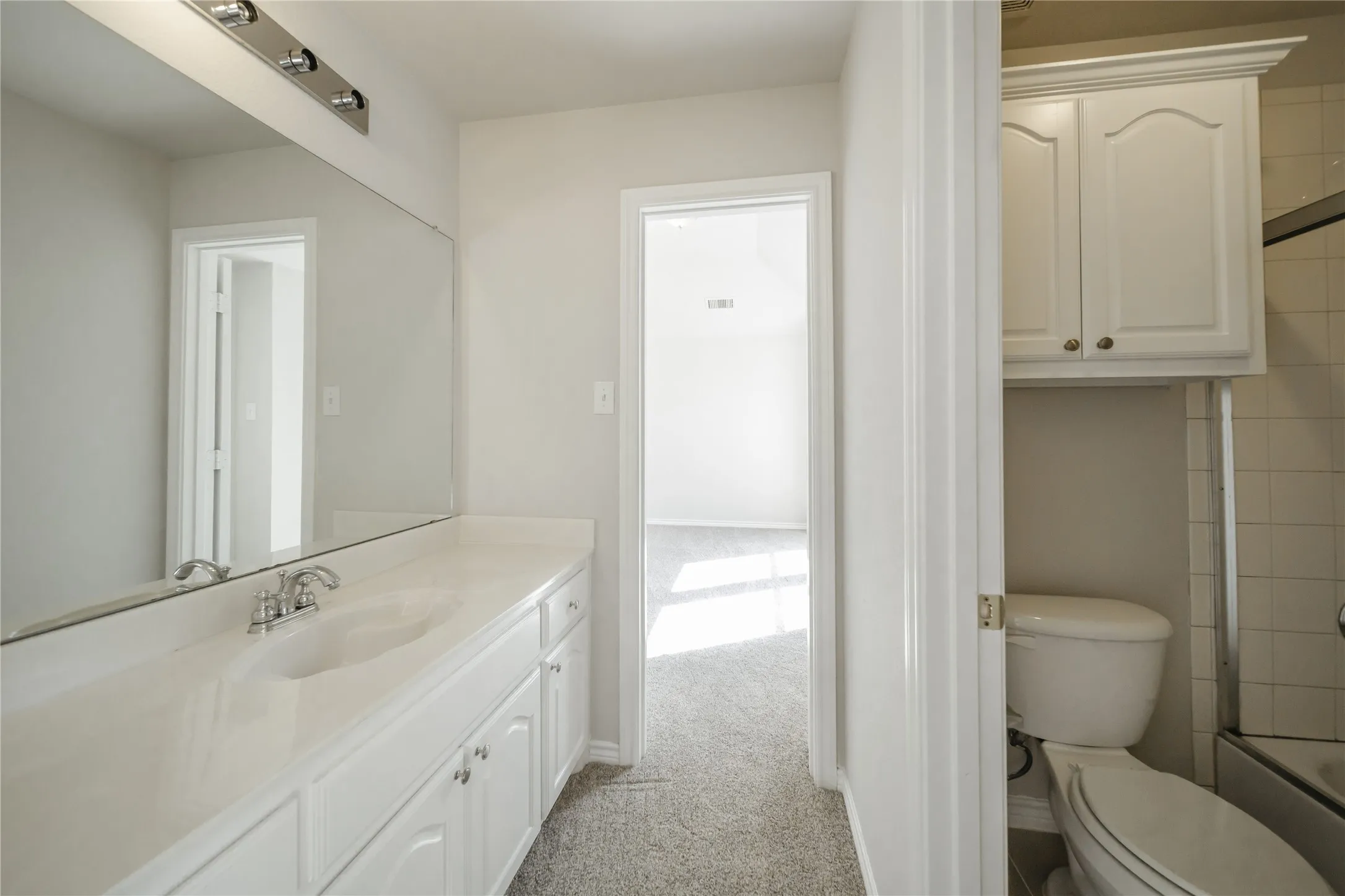 Bathroom vanity featuring a single basin, chrome faucet, and white countertop