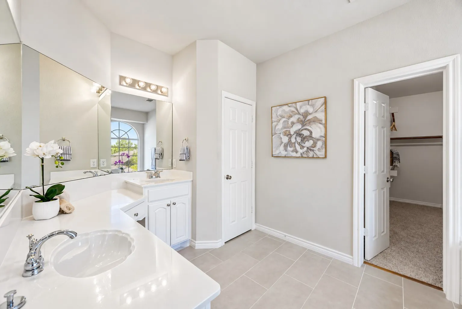 Dual vanity with white countertops, chrome fixtures, and integrated sinks