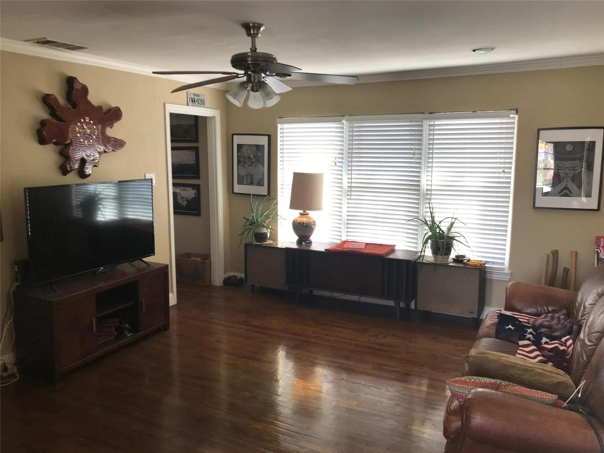 Hardwood flooring throughout a living space featuring a ceiling fan with integrated lighting