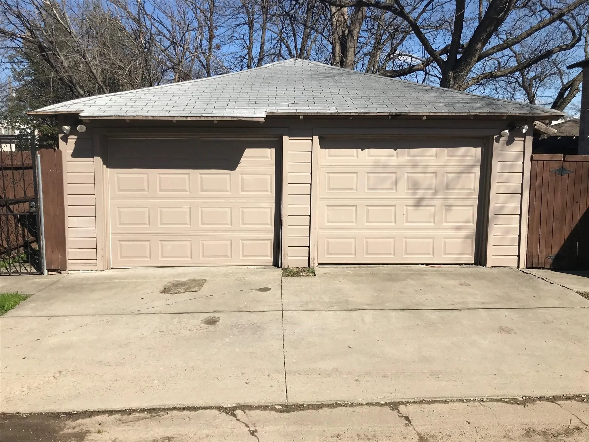 Detached two-car garage with panel-style doors and horizontal siding