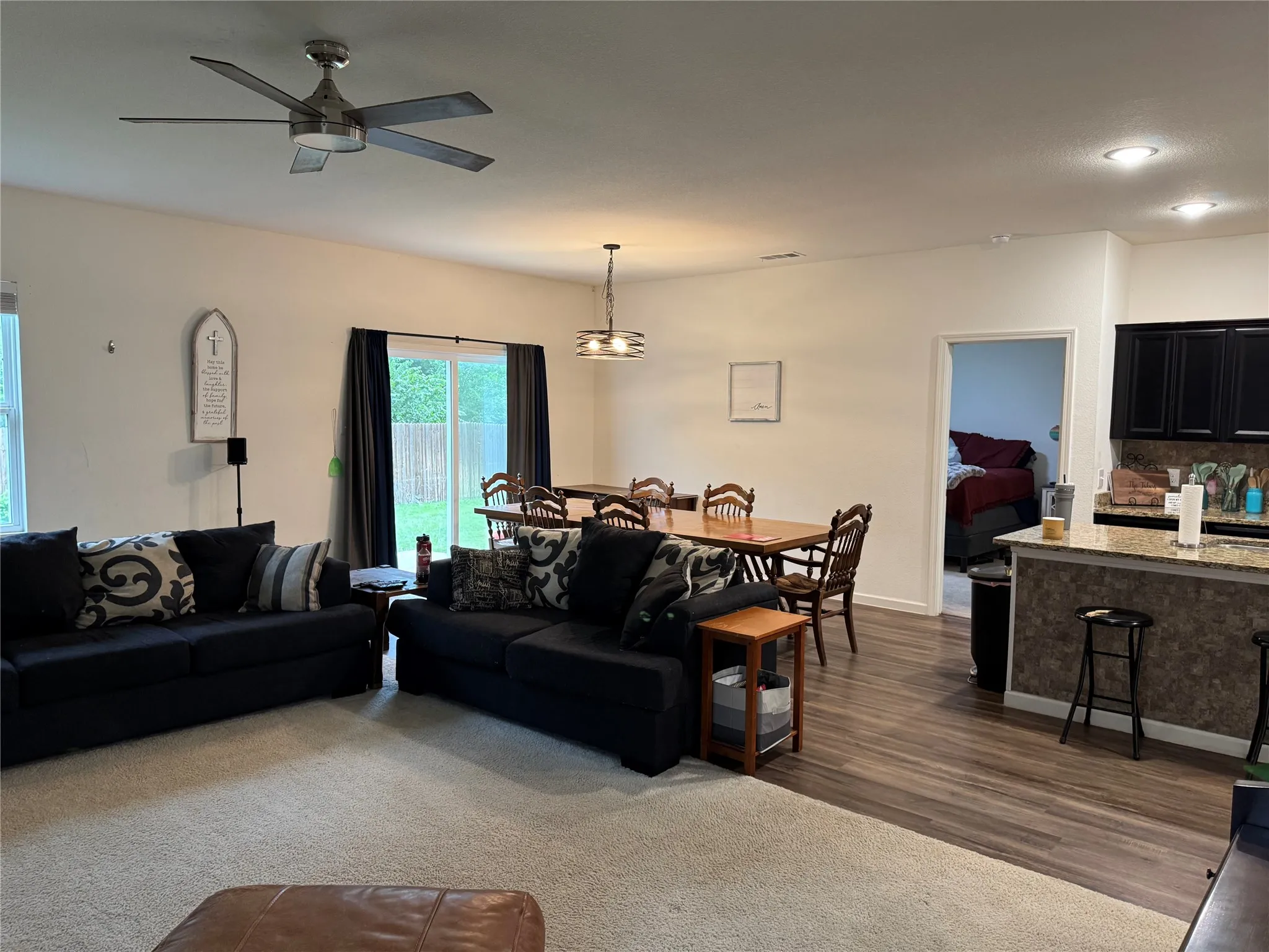 Open-concept living area featuring a ceiling fan with integrated lighting, wood-finish flooring, and recessed lighting