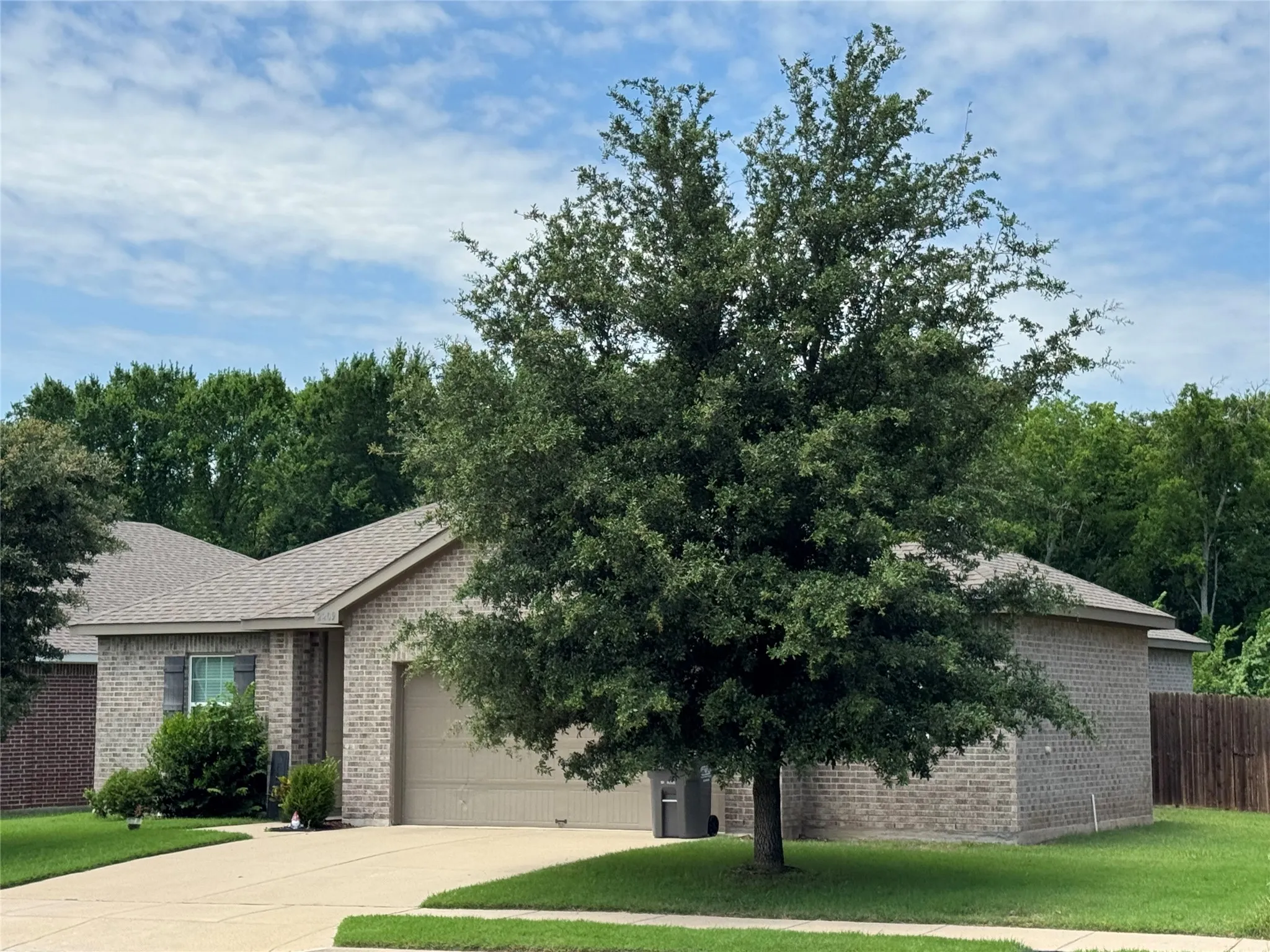 Brick exterior residence featuring a two-car garage with a complementary garage door