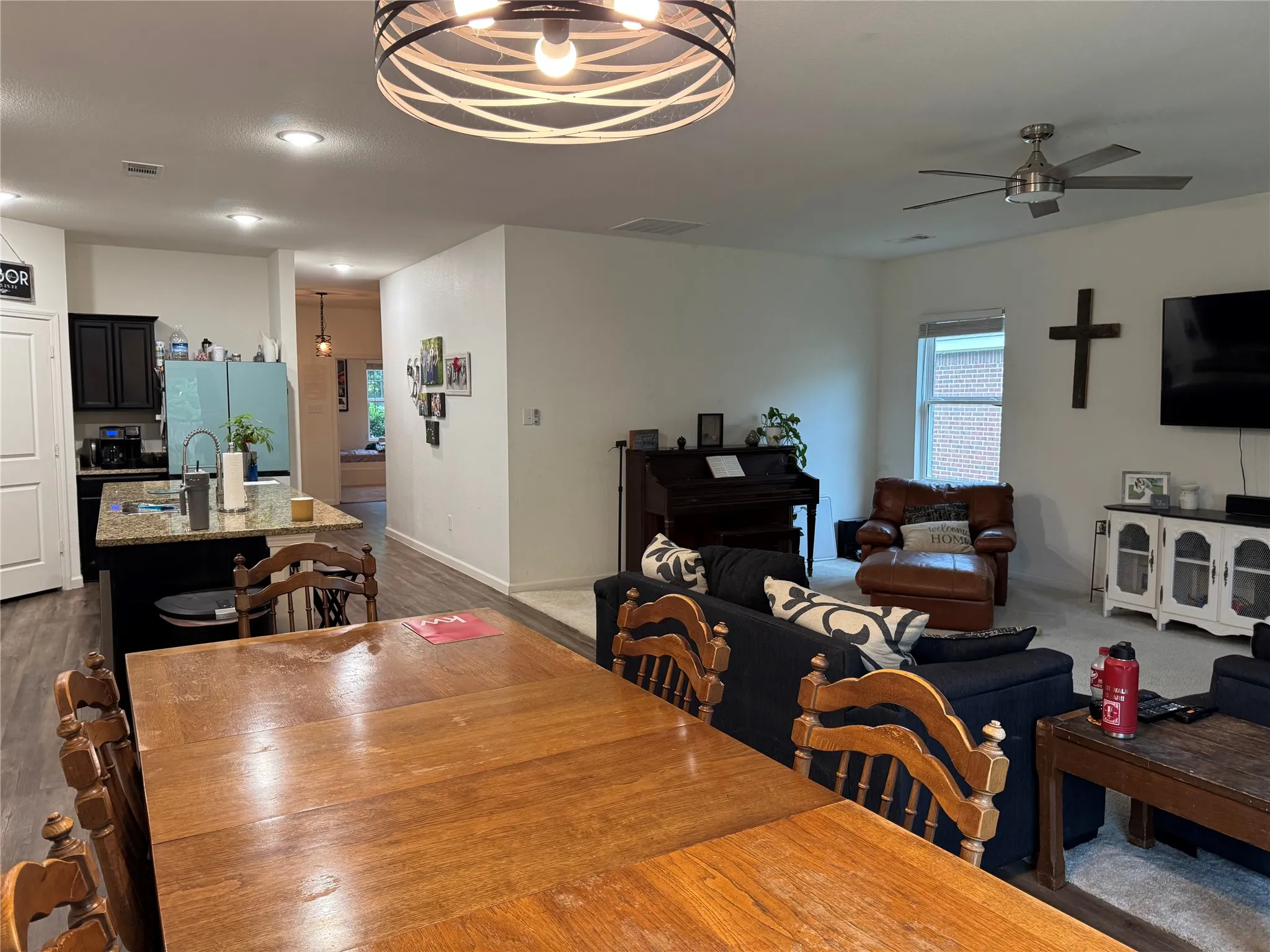Spacious dining area featuring wood-finish flooring and a contemporary overhead light fixture