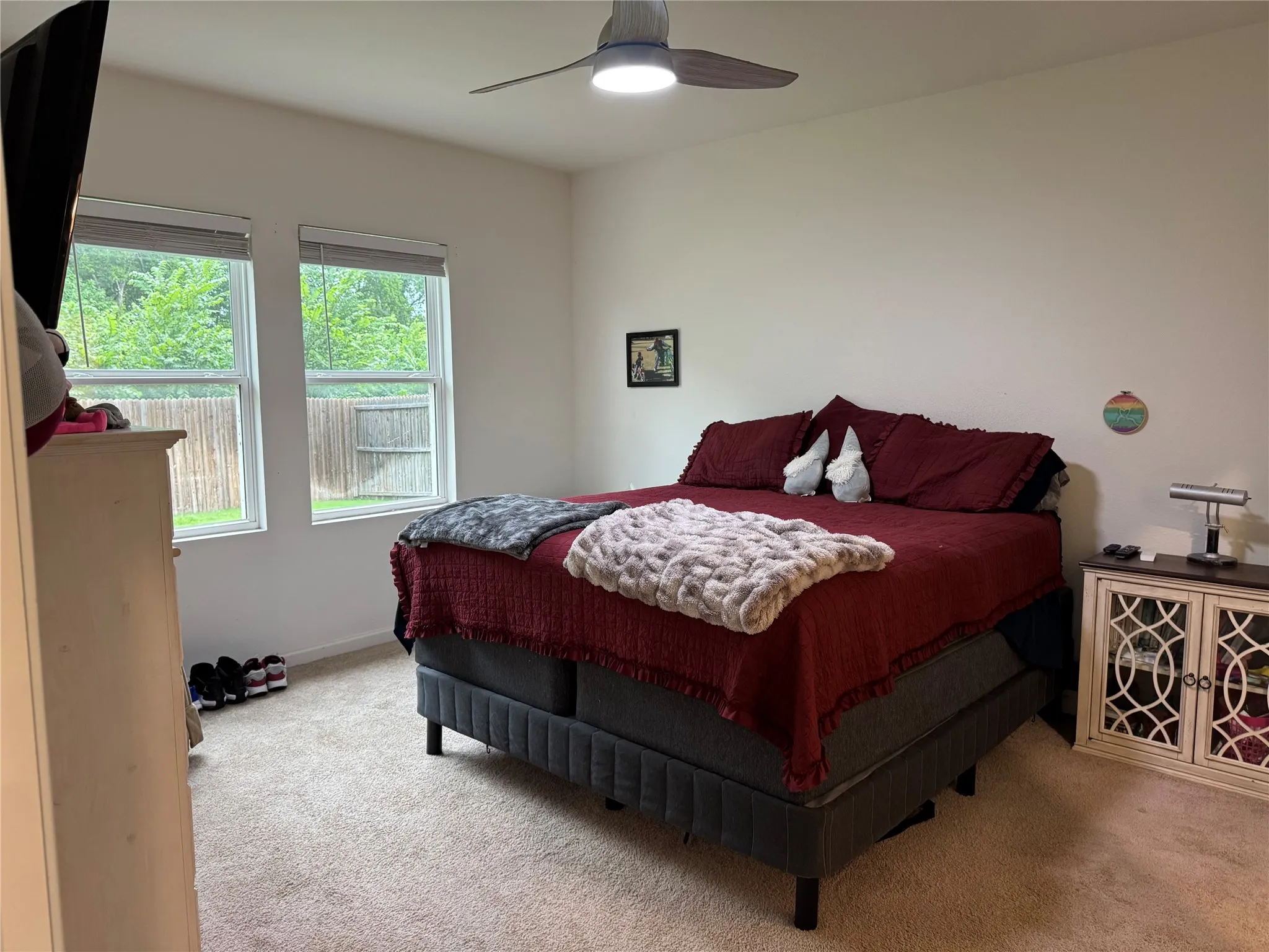 Spacious interior featuring two windows with horizontal blinds, neutral wall paint, and light-toned carpet flooring