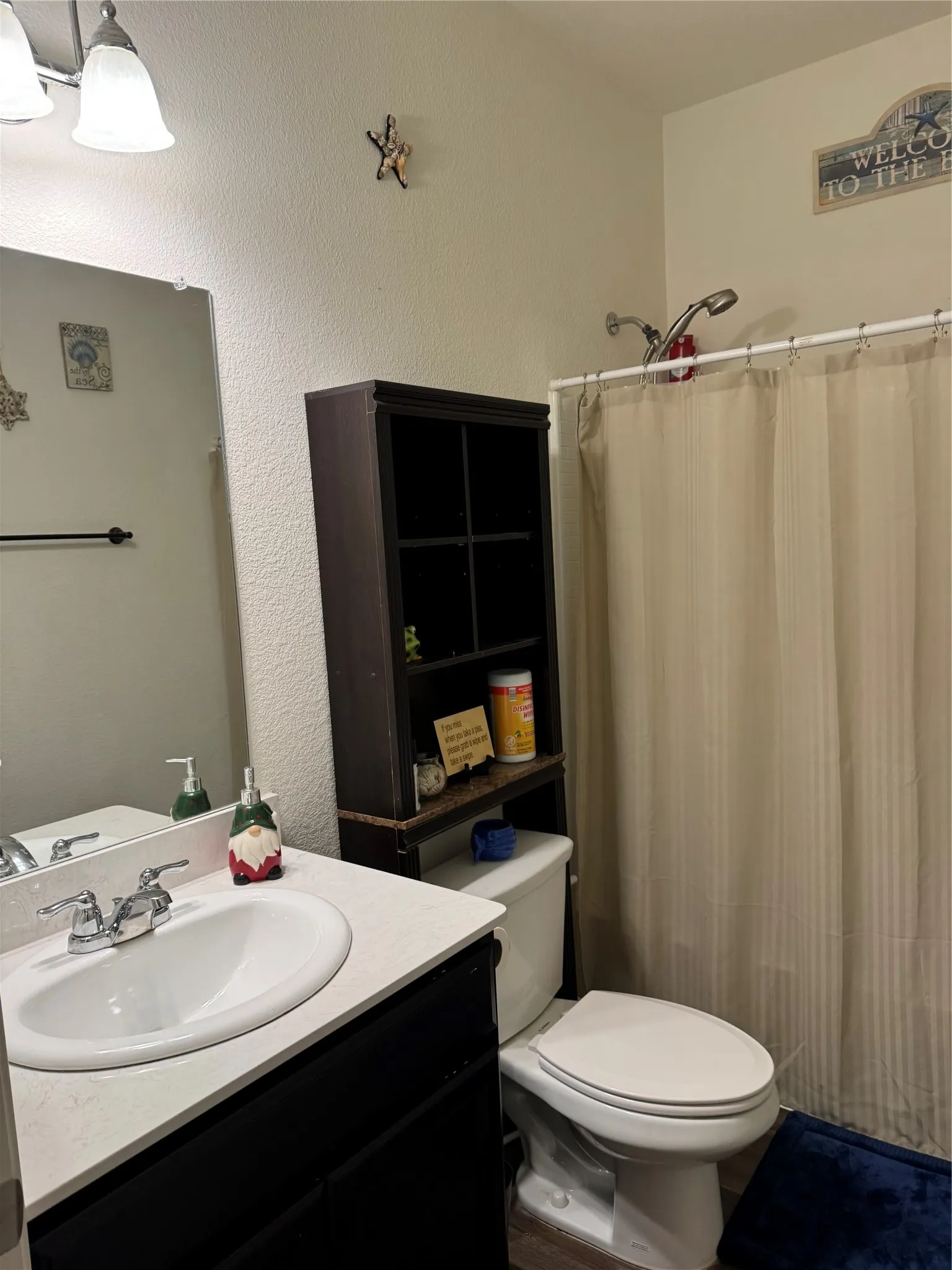 Bathroom featuring a white oval sink with a chrome faucet, a dark vanity cabinet, and a white countertop
