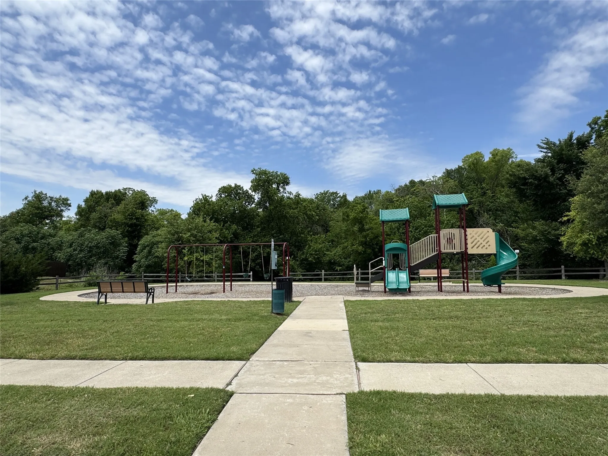 Community playground featuring a multi-level play structure with slides and swings