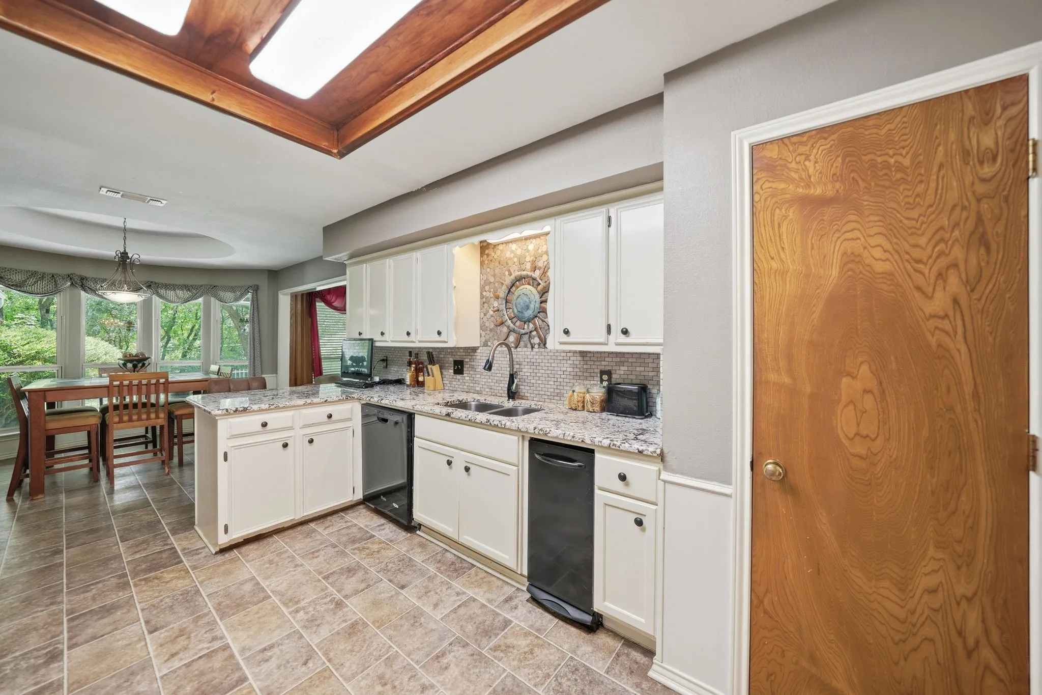 Kitchen featuring white cabinetry, a central island with countertop, and black​​‌​​​​‌​​‌‌​‌‌​​​‌‌​‌​‌​‌​​​‌​​ appliances