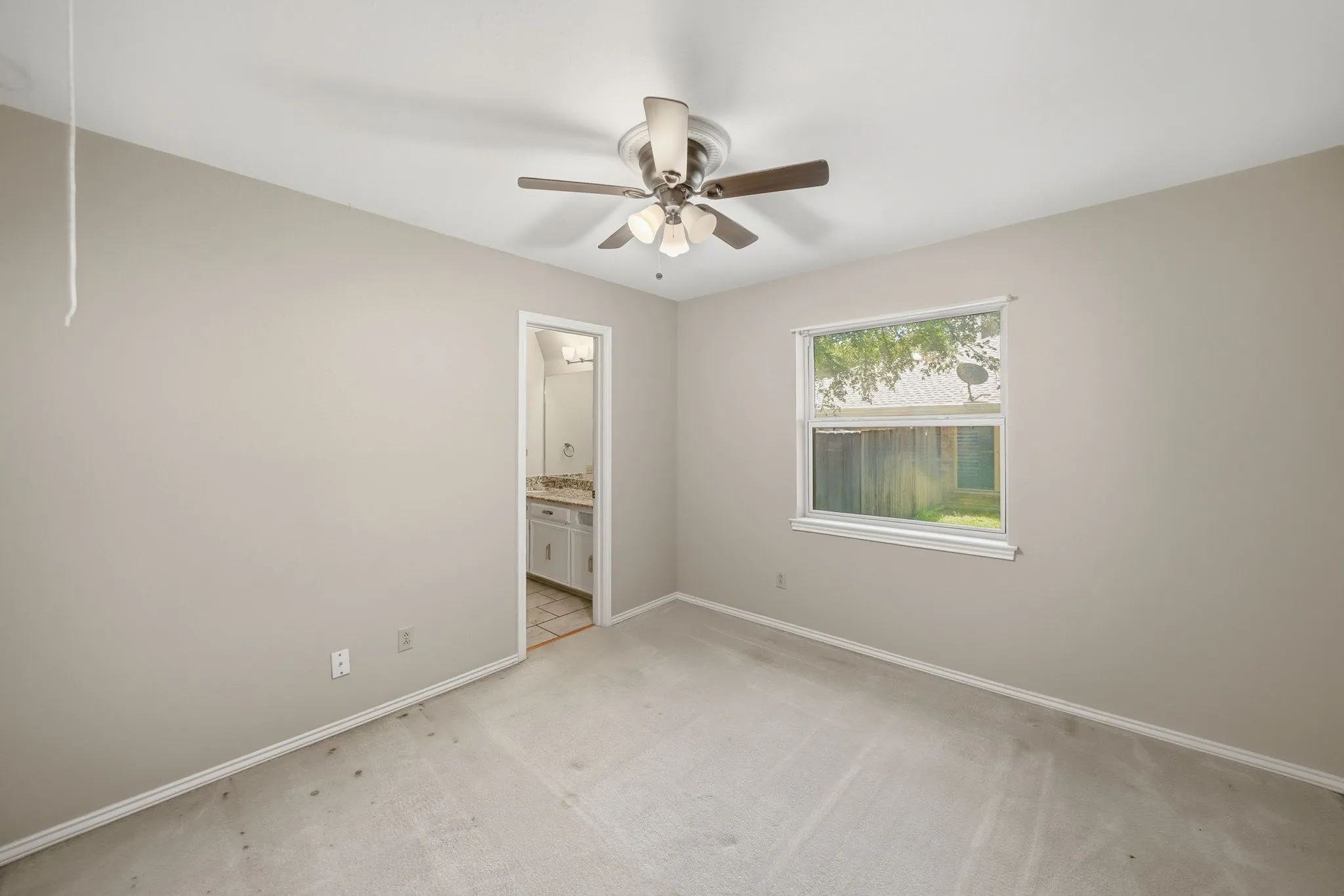 Neutral-toned bedroom featuring a ceiling fan, carpeted flooring, and a single window