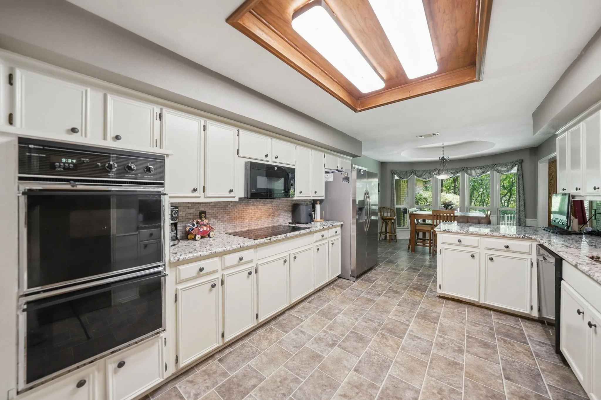 Kitchen featuring white cabinetry, built-in double oven, and granite countertops