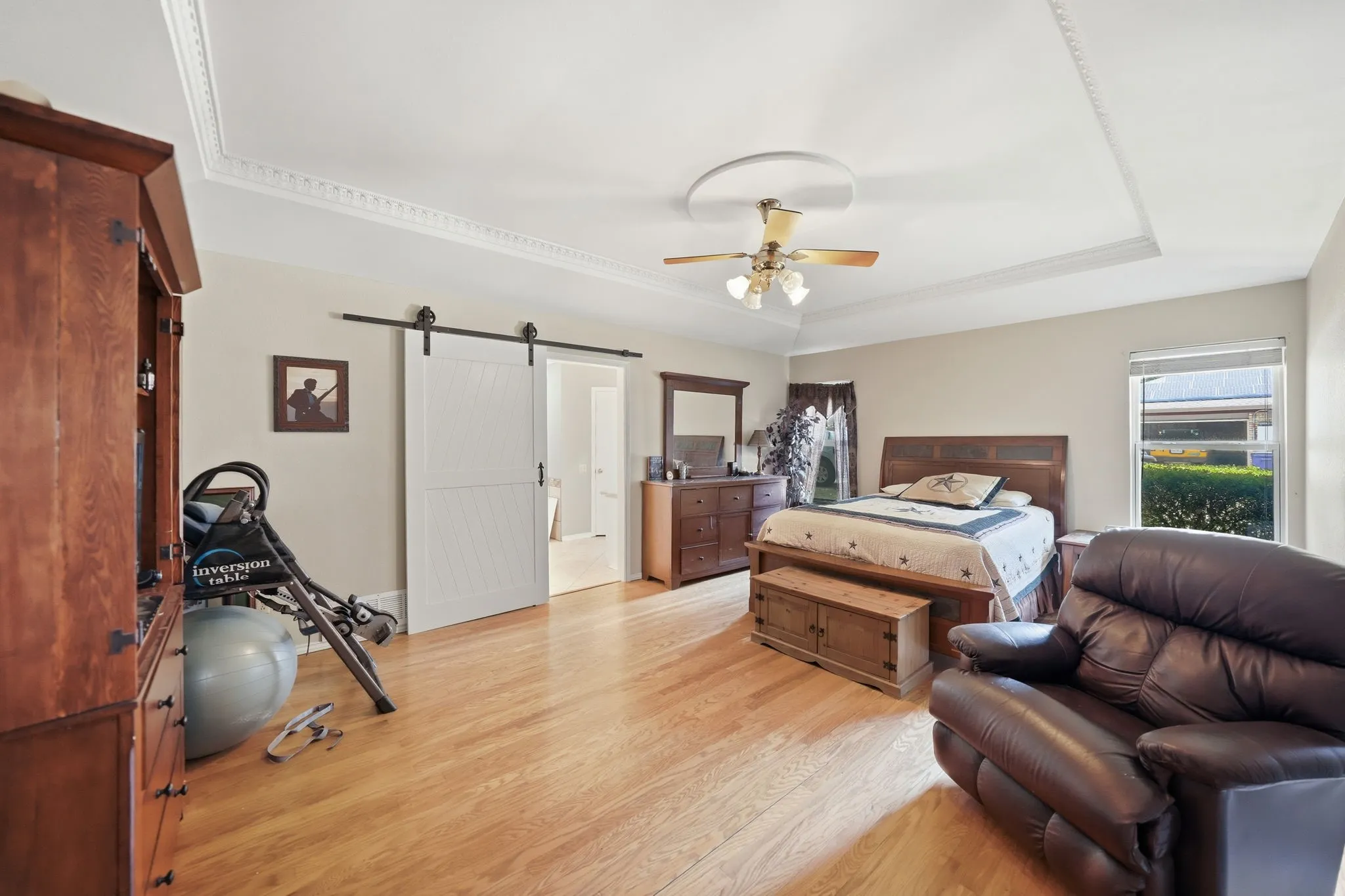 Spacious room featuring wood-finish flooring and a tray ceiling