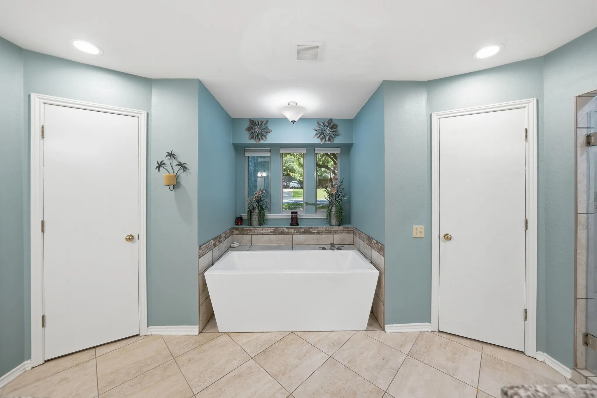 Soaking tub with a tile surround and two windows