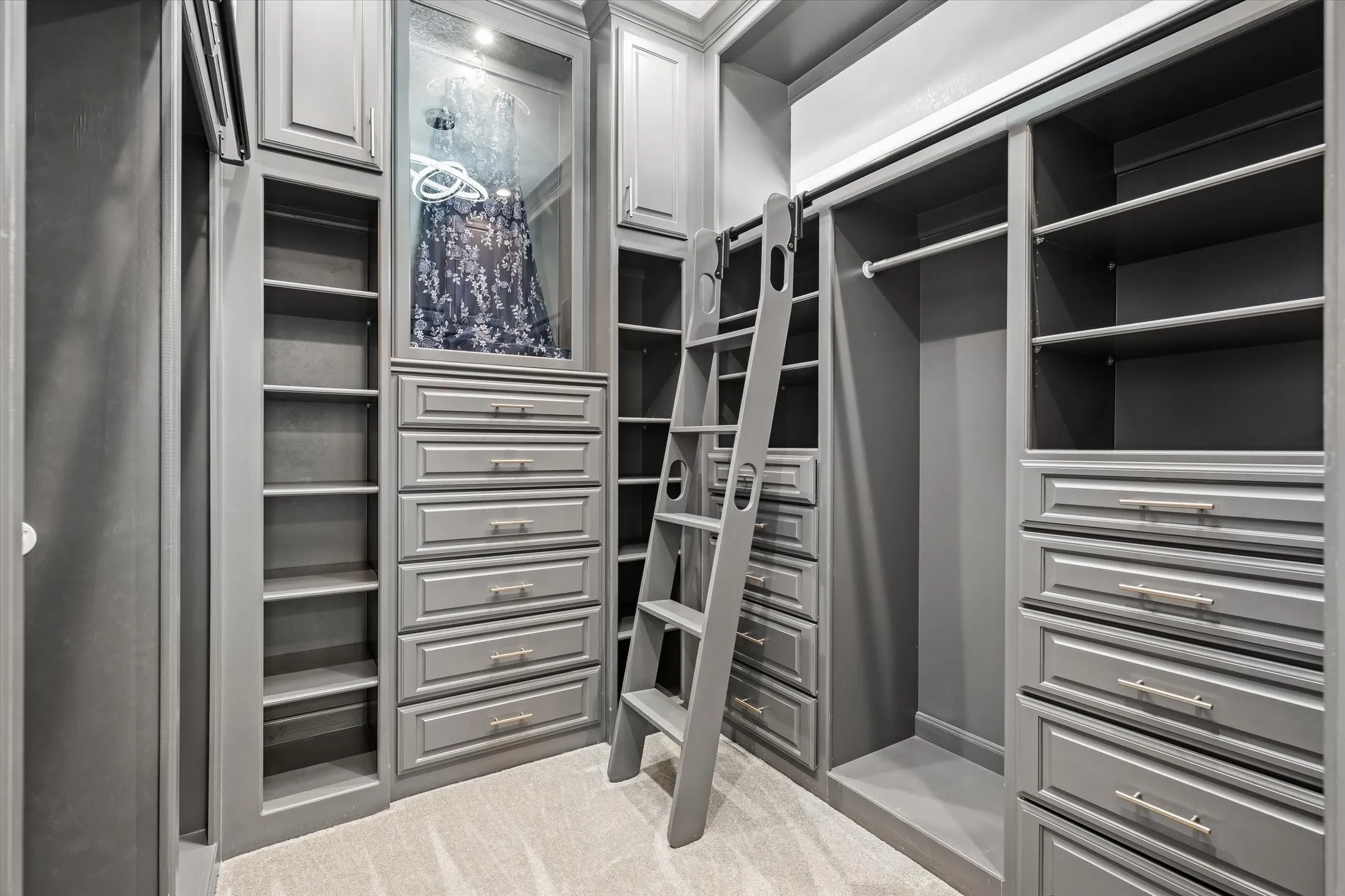 Primary bedroom walk in closet with so many built ins, and a lighted shadow box to display the dress of your dreams