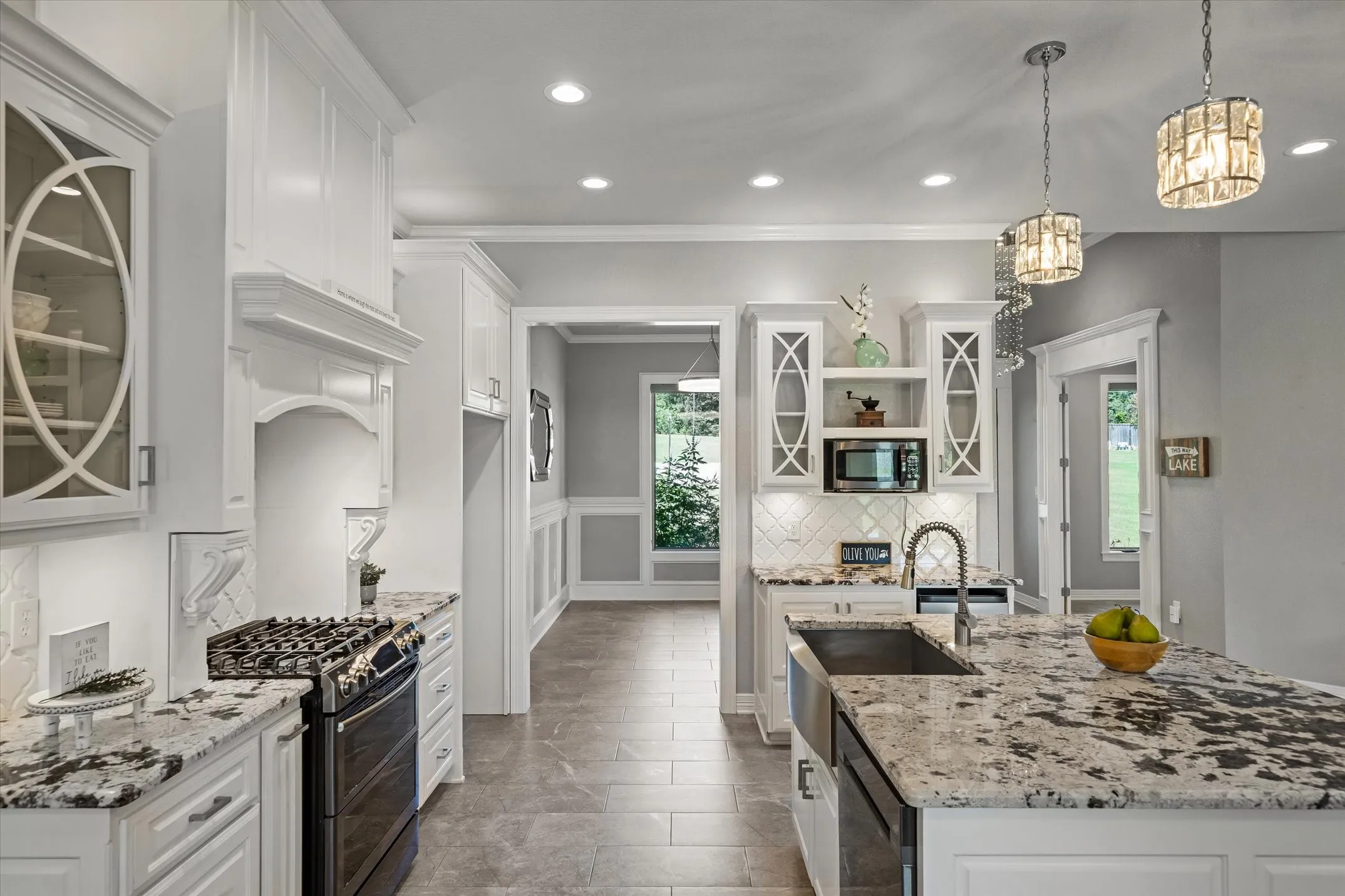 Gas range, quartz countertops and glass front cabinets