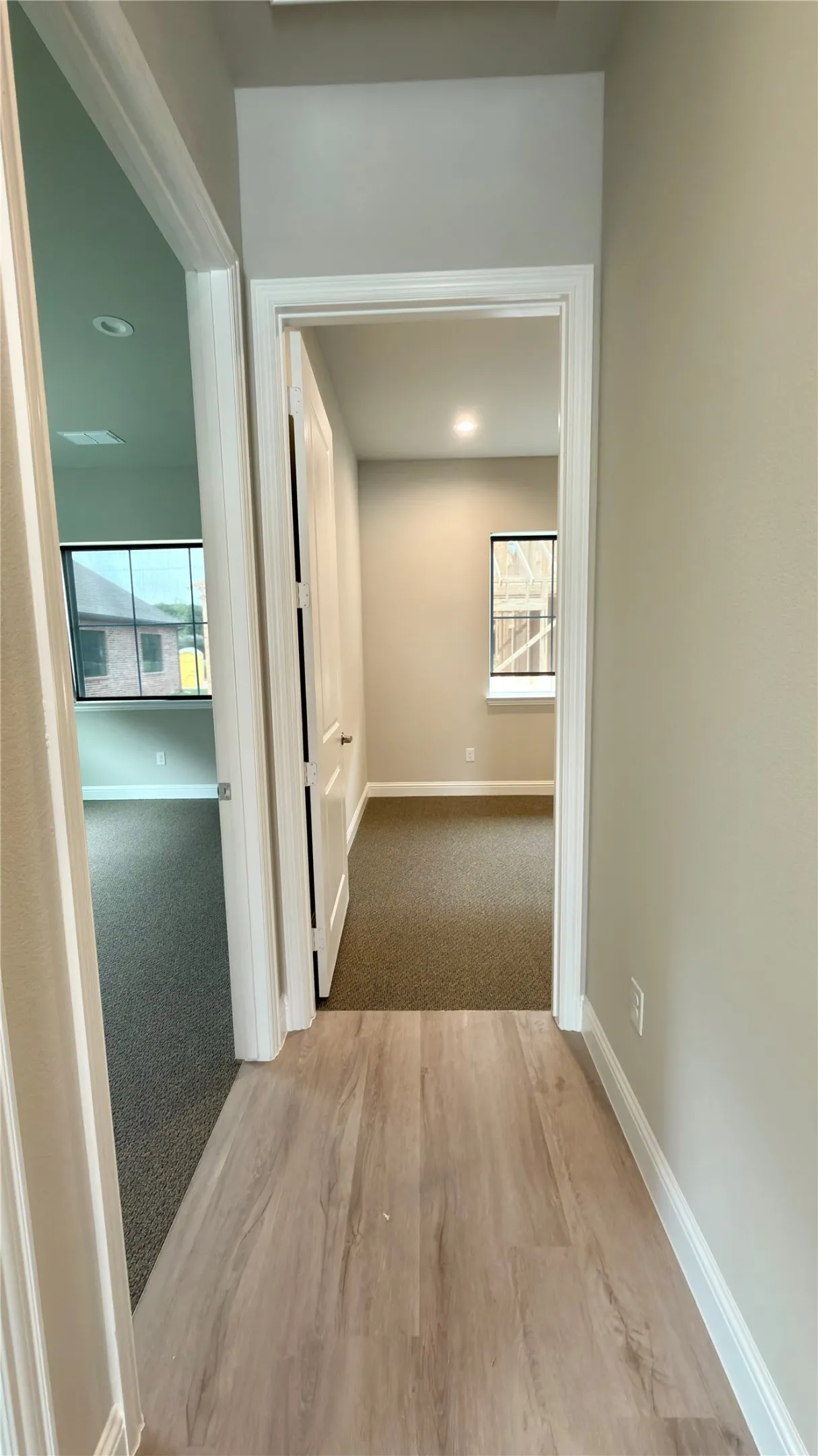 Light wood-finish flooring in a hallway with neutral wall tones