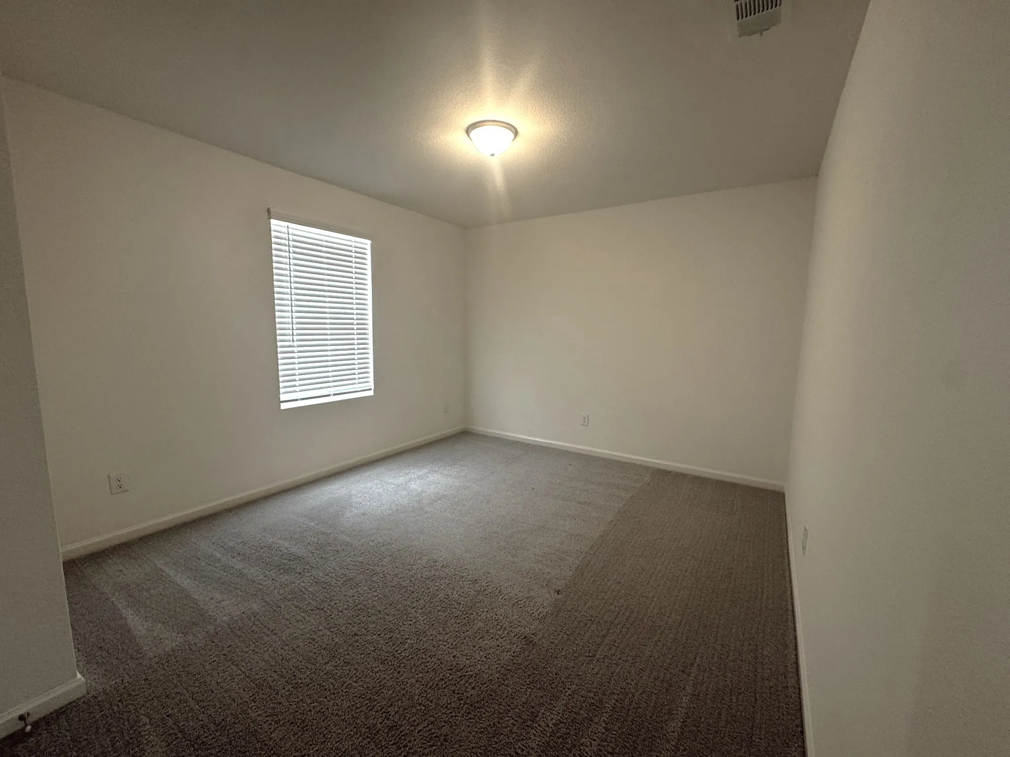 Neutral wall tones complement the neutral carpet flooring