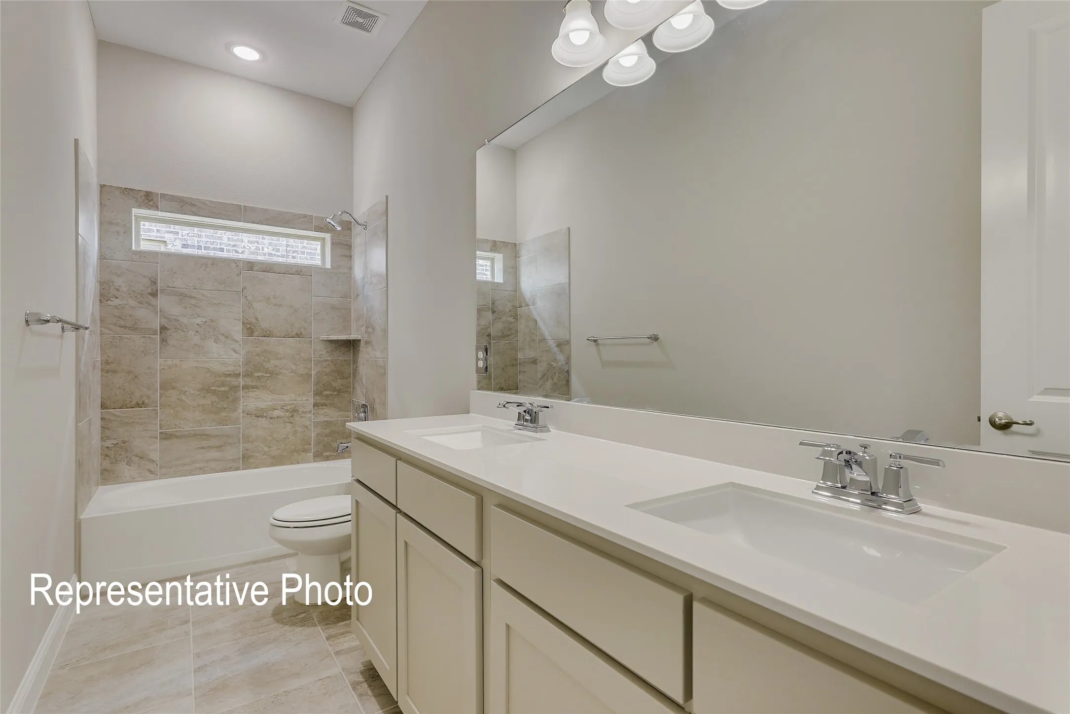 Bathroom featuring a dual vanity with undermount sinks, a large mirror, and chrome fixtures