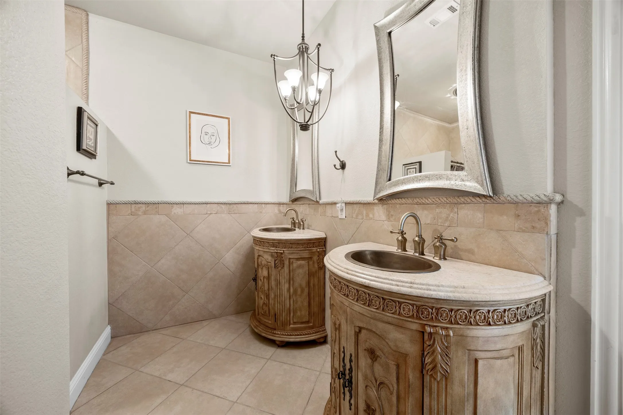 Elegant ensuite bath with dual custom vanities, decorative lighting, & timeless finishes designed to complement the spacious secondary suite.